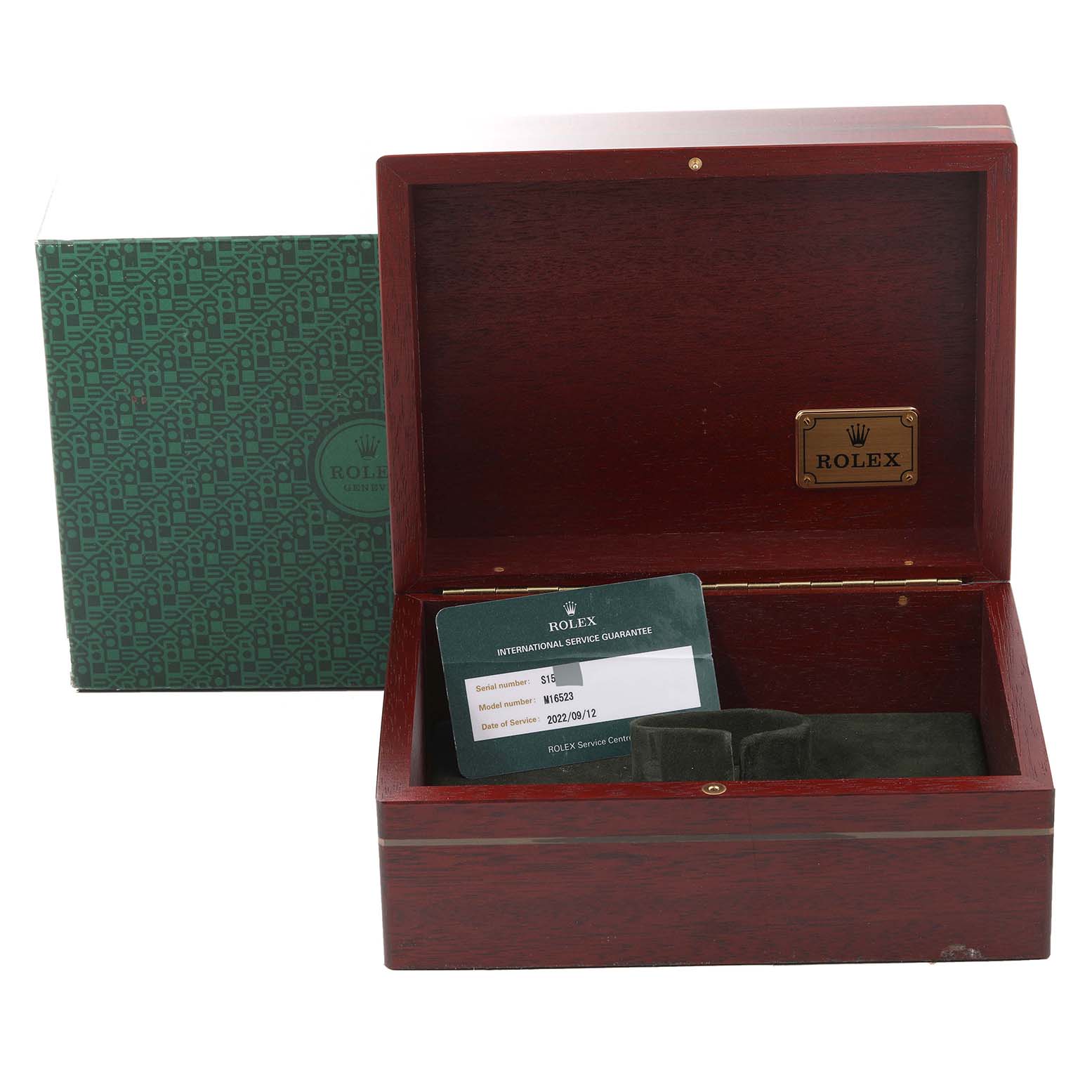 The image shows an open Rolex watch box for the Daytona model, displaying a guarantee card inside.