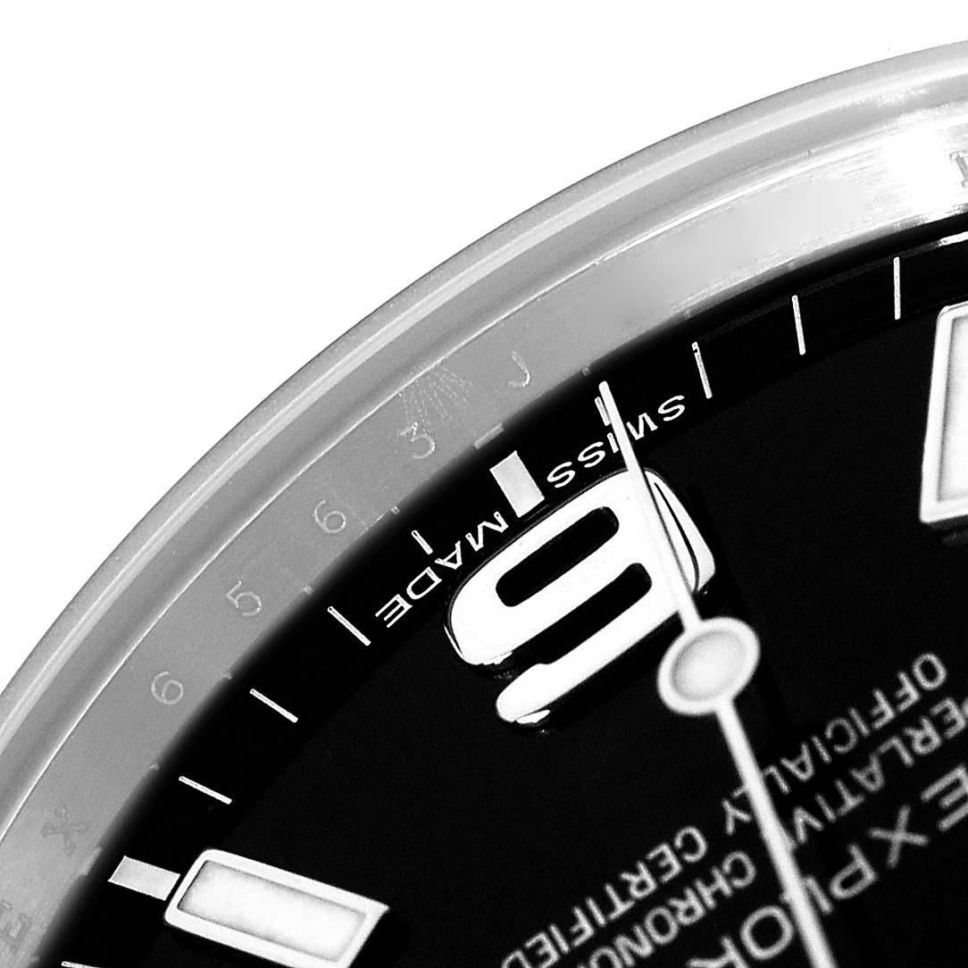 The image shows a close-up of the dial of a Rolex Explorer 214270 Men
s Stainless Steel Black Dial watch, focusing on the "9" numeral and "SWISS MADE" text.