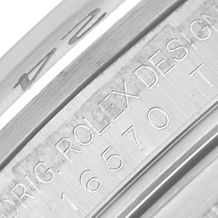 This close-up image shows the engraved case side of the Rolex Explorer 16570T Men's Stainless Steel Black Dial 16570T Men's Stainless Steel Black Dial model, including serial and design numbers.