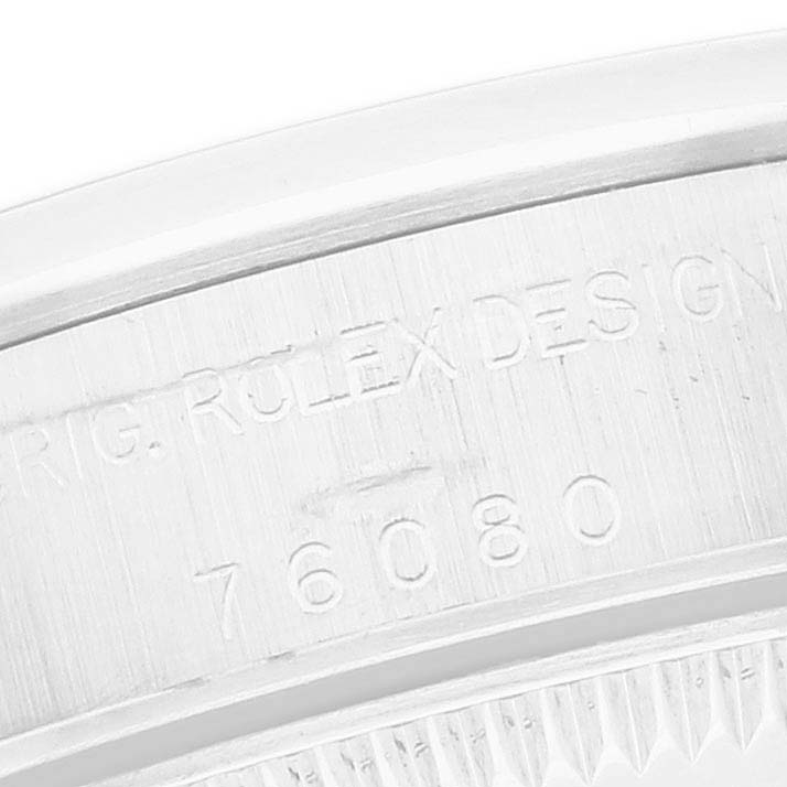 The image shows a close-up of the side of a Rolex Oyster Perpetual 76080 Women
s Stainless Steel Silver Dial, highlighting engraved text on its casing.