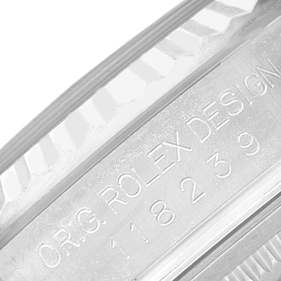 The image shows a close-up of the case side engraving and fluted bezel of a Rolex President 118239 Men's White Gold Black Dial 118239 Men's White Gold Black Dial model.