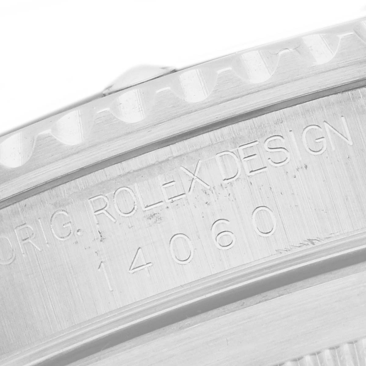 The image shows a close-up of the edge and serial engraving on a Rolex Submariner 14060 Men
s Stainless Steel Black Dial, highlighting the bezel and case details.