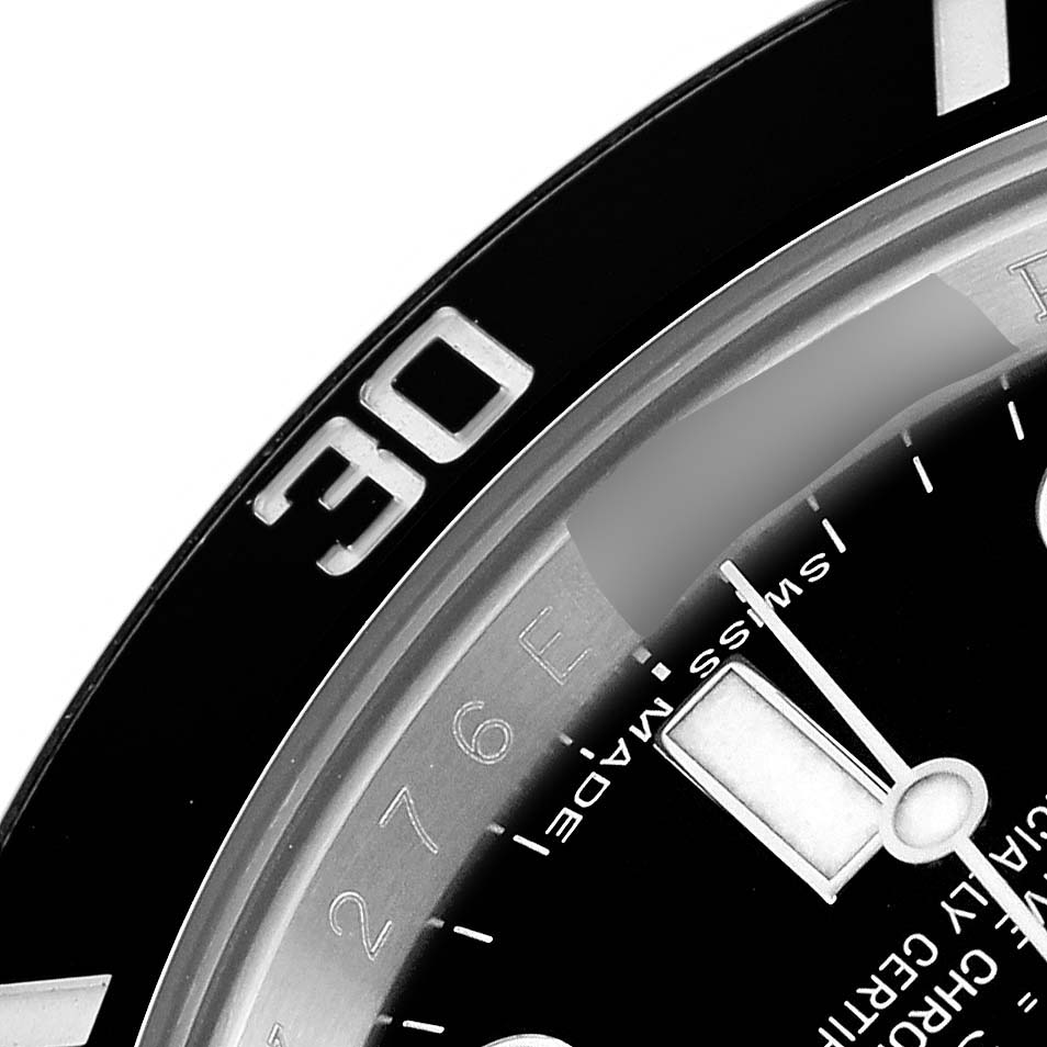 The image shows a close-up of the Rolex Submariner 114060 Men
s Stainless Steel Black Dial
s bezel, dial, and hour hand from an angled perspective.