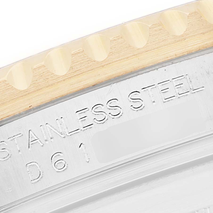 The image shows a close-up of the bezel outer edge and engraved text on the case back of a Rolex Submariner 16613 Men
s Steel and Gold (two tone) Black Dial.