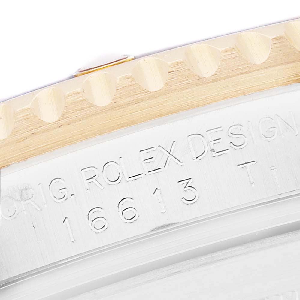 The image shows the side engraving of a Rolex Submariner 16613 Men
s Steel and Gold (two tone) Black Dial, displaying its design and model number.