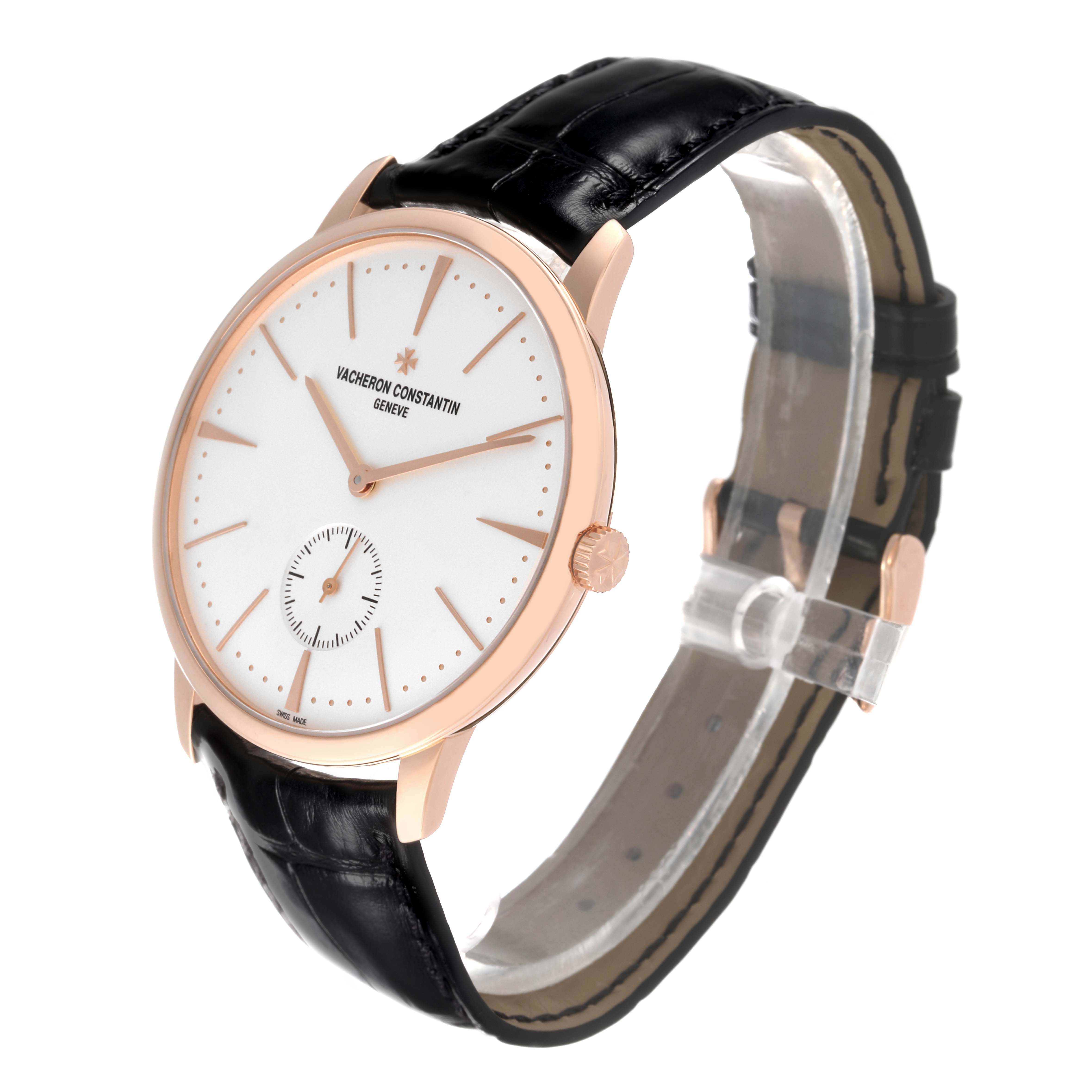 The image shows a side angle view of a Vacheron Constantin Patrimony 1110U/000R Men's Rose Gold Silver Dial 1110U/000R Men's Rose Gold Silver Dial watch, highlighting its white dial, rose gold case, and black leather strap.