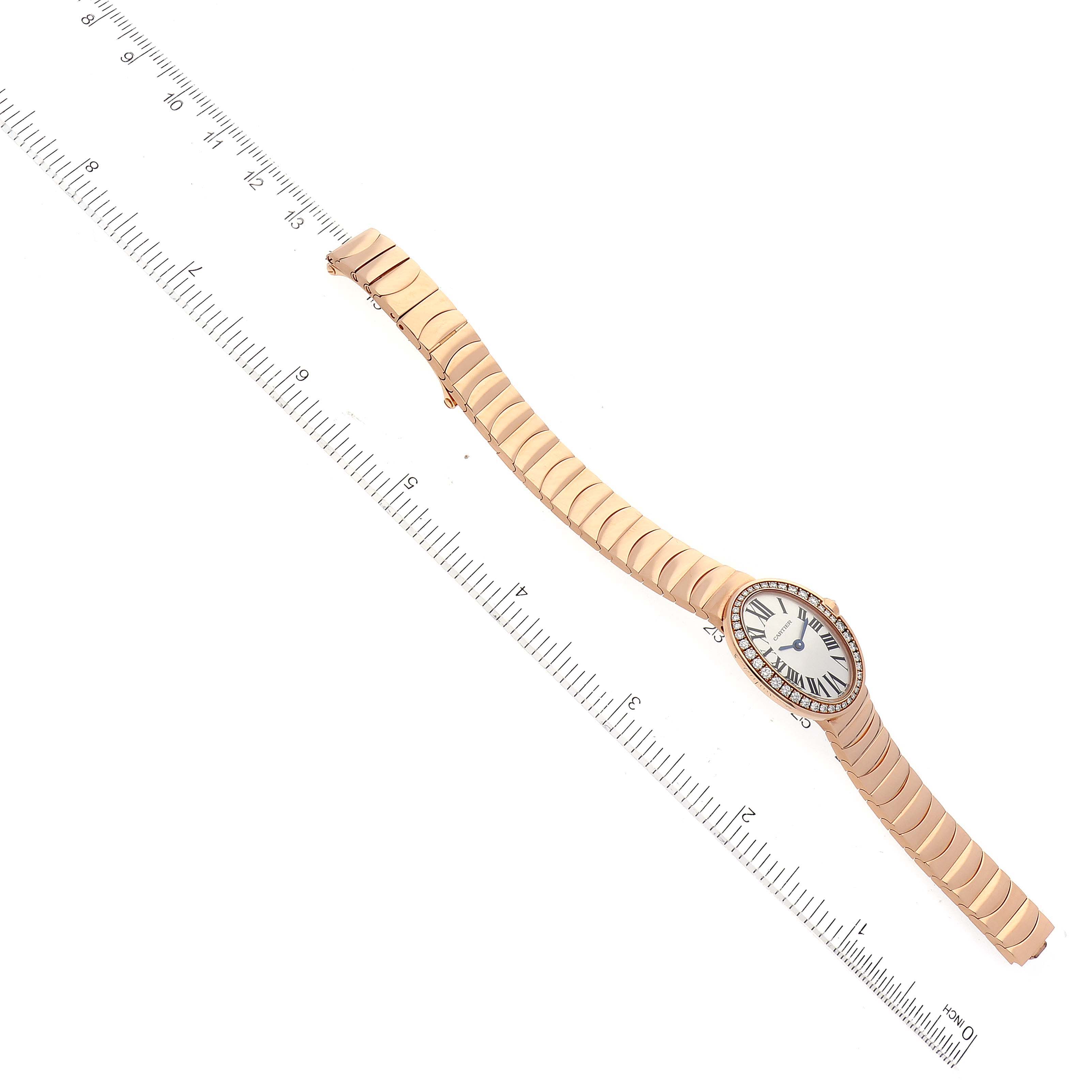 This image shows an overhead view of a Cartier Baignoire WB520026 Women's Rose Gold Silver Dial WB520026 Women's Rose Gold Silver Dial watch with a measuring ruler alongside.
