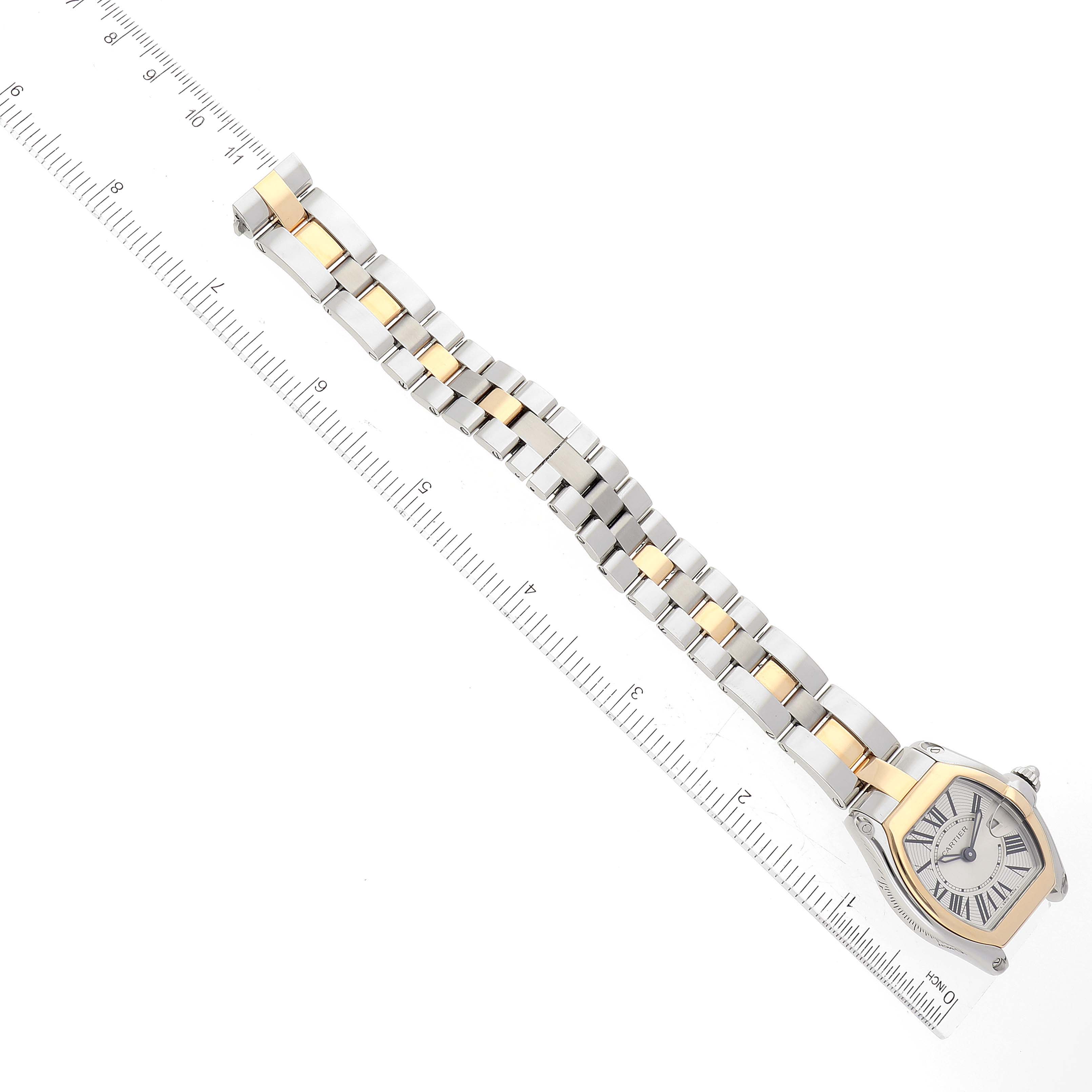 The image shows a Cartier Roadster W62026Y4 Women
s Steel and Gold (two tone) Silver Dial W62026Y4 Women
s Steel and Gold (two tone) Silver Dial watch laid flat with a ruler next to it for scale.