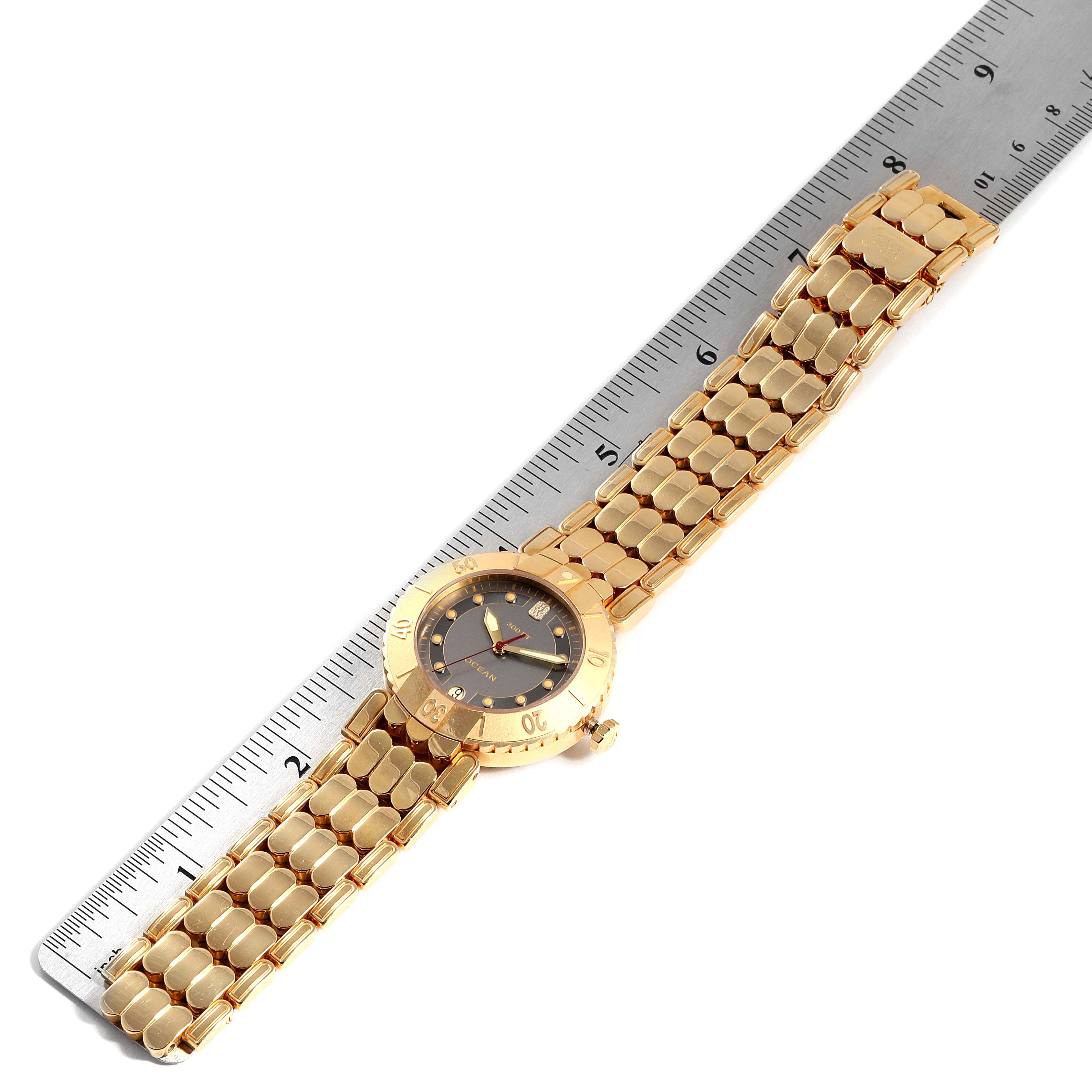 This image shows the Harry Winston N114-AD Men's Yellow Gold Grey Dial N114-AD Men's Yellow Gold Grey Dial Submariner Ocean 38mm 18K Yellow Gold Mens Watch laid flat next to a ruler.