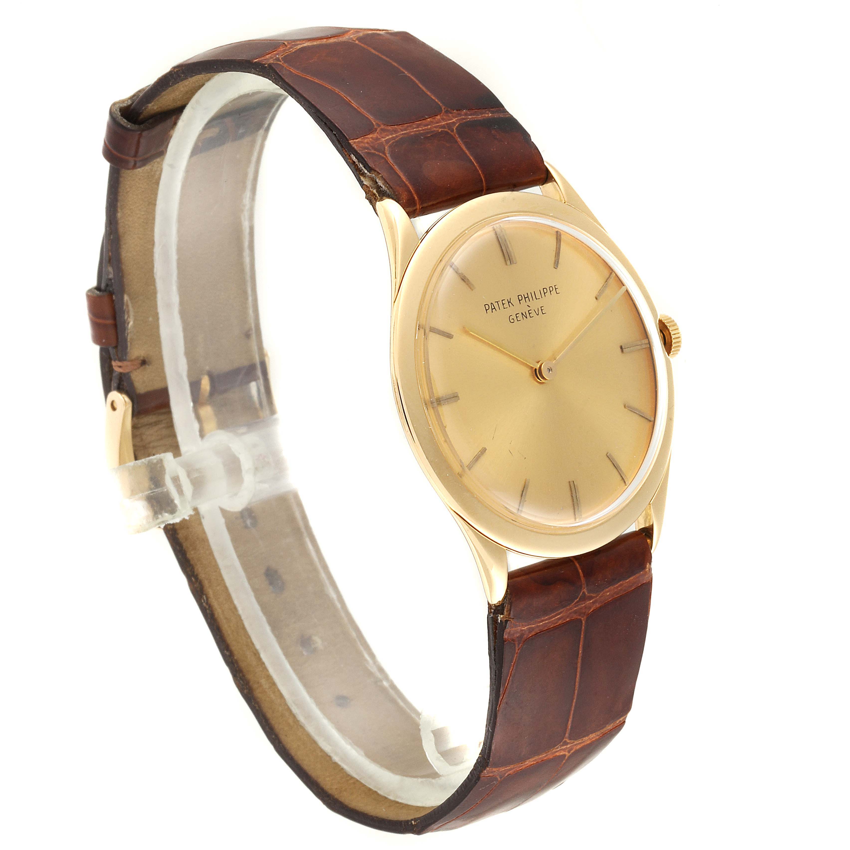 The image shows a Vintage Patek Philippe watch at a slight angle, showcasing its gold dial, leather strap, and side crown.
