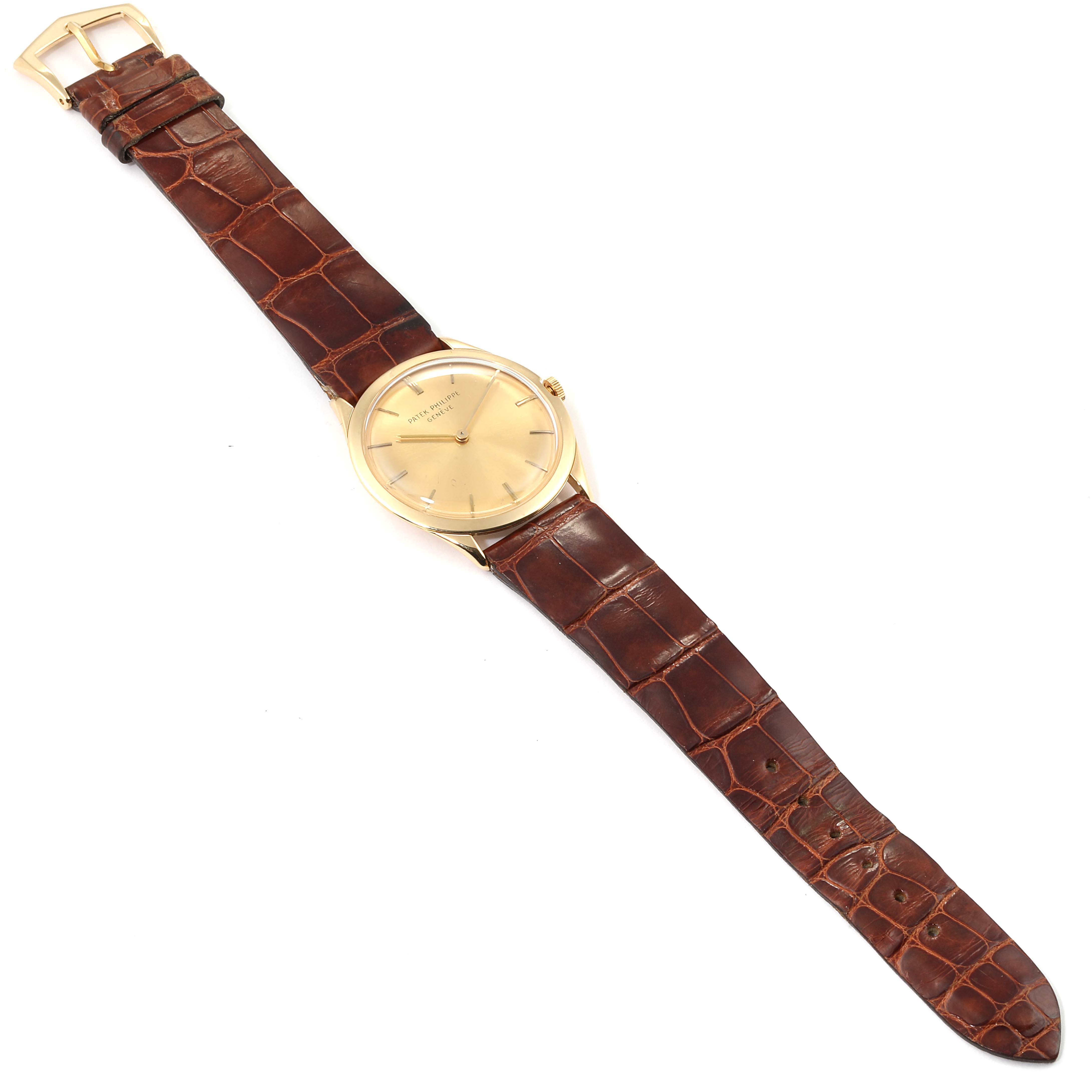 The image shows a top-down view of a Vintage Patek Philippe watch, including its gold case and brown leather strap.
