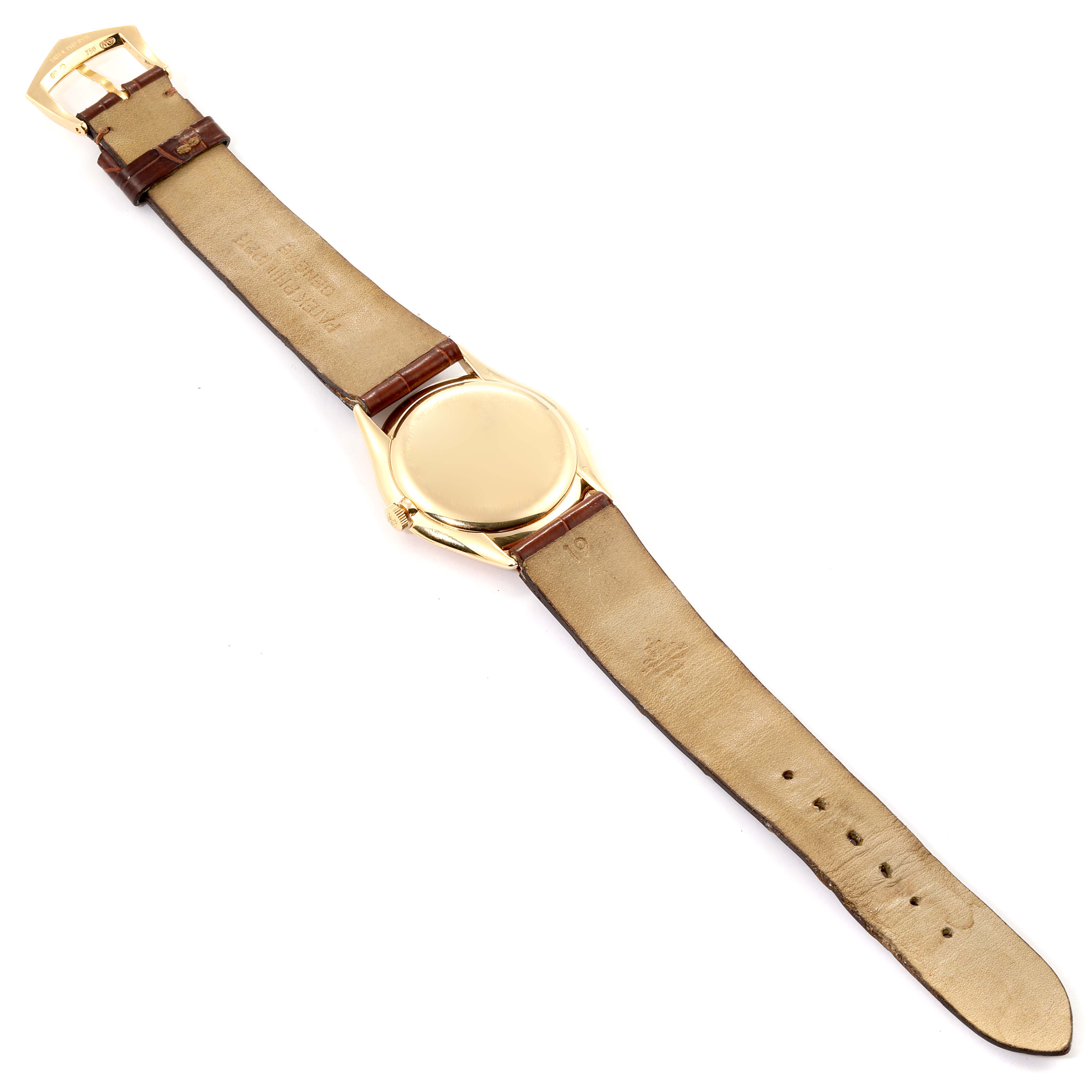 This image shows the back and strap of a Vintage Patek Philippe watch, including the golden case and leather strap.