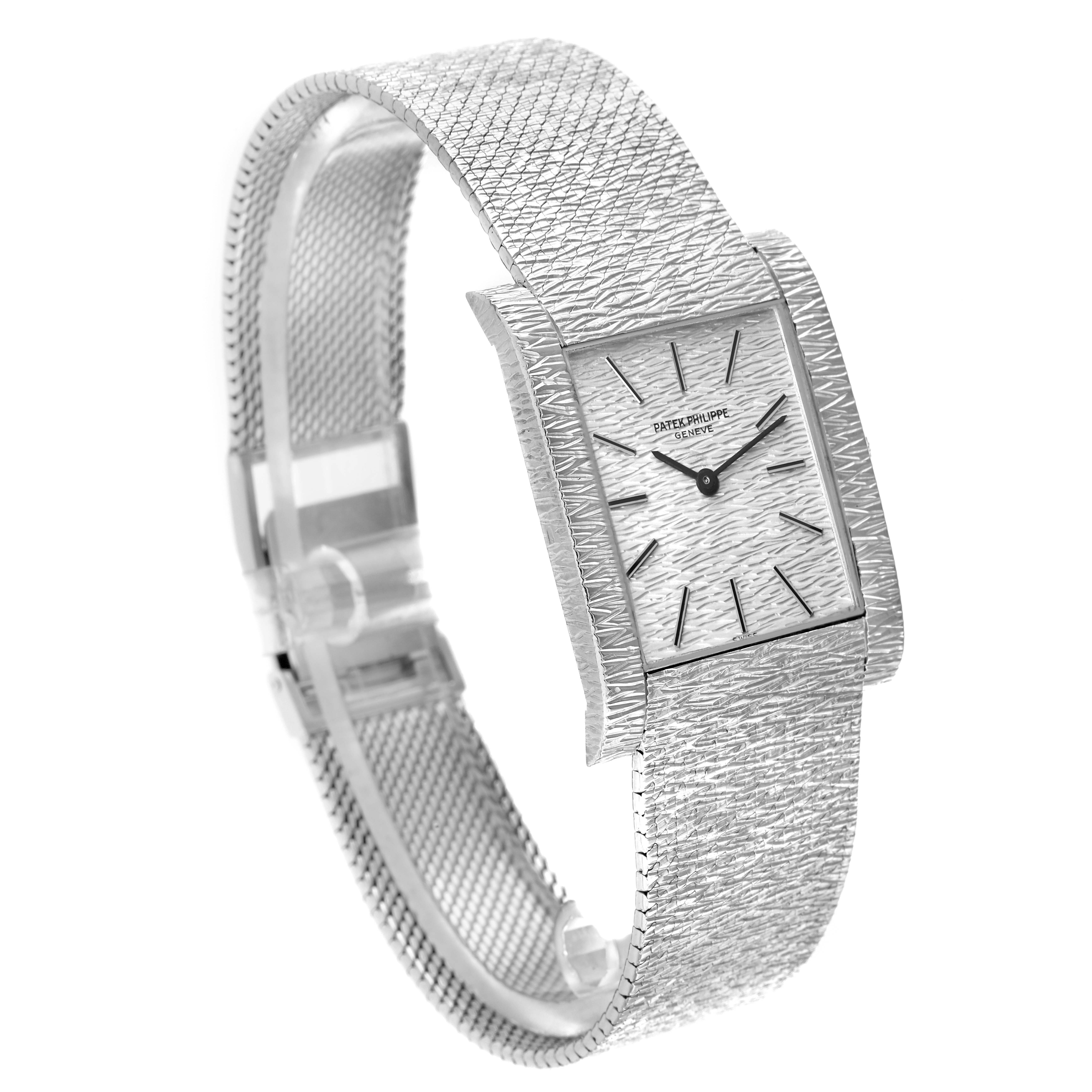 The Patek Philippe Vintage 3553/1 Men
s White Gold Silver Dial model is shown at a three-quarter angle, highlighting its textured rectangular face and integrated bracelet.