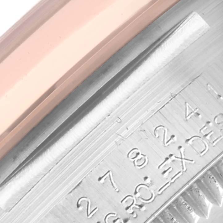 This close-up image shows a portion of the Mid-Size Rolex watch, specifically the edge of the bezel and the engraved details.