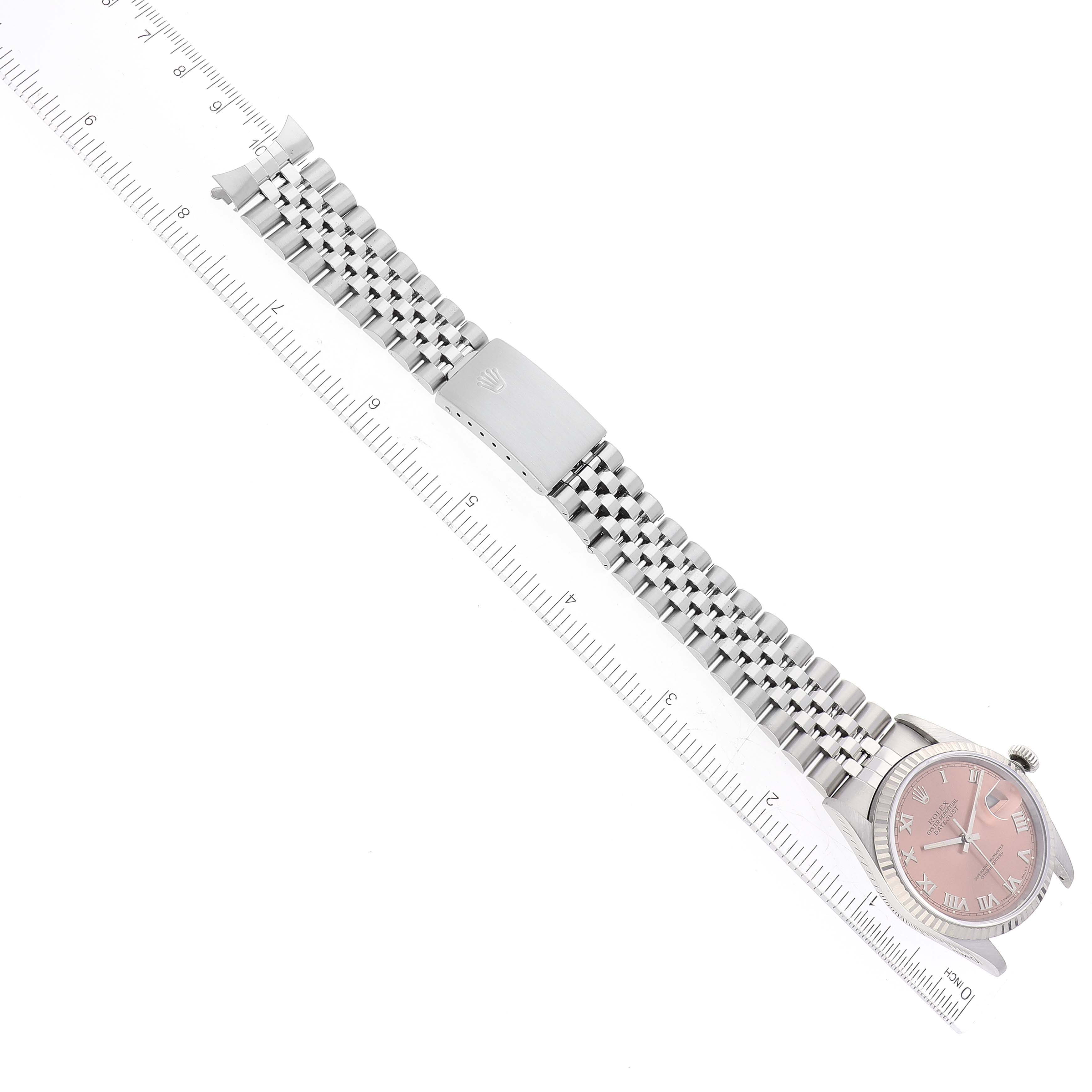 This image shows a Rolex Datejust 16234 Men's Stainless Steel Pink Dial 16234 Men's Stainless Steel Pink Dial watch laid flat, highlighting the dial, bracelet, and clasp next to a ruler for scale.