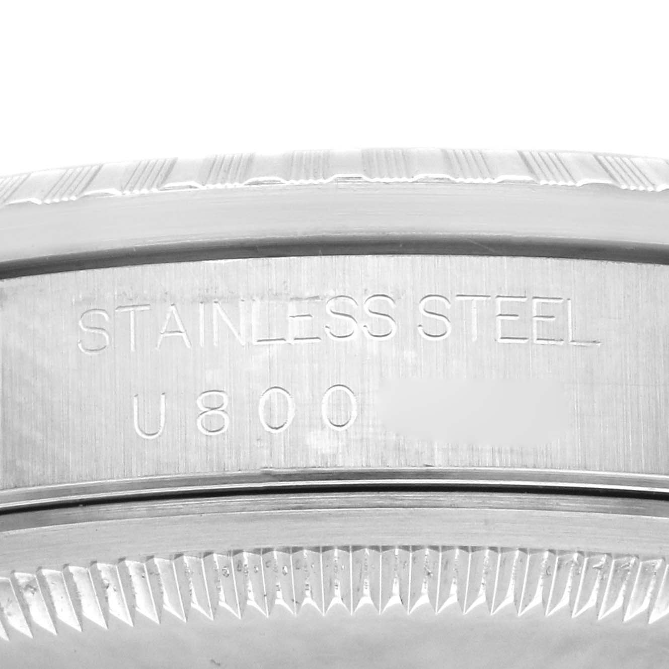 This close-up image shows the case back of a Rolex Datejust 16220 Men
s Stainless Steel White Dial 16220 Men
s Stainless Steel White Dial, highlighting the "STAINLESS STEEL" marking and part of the serial number.