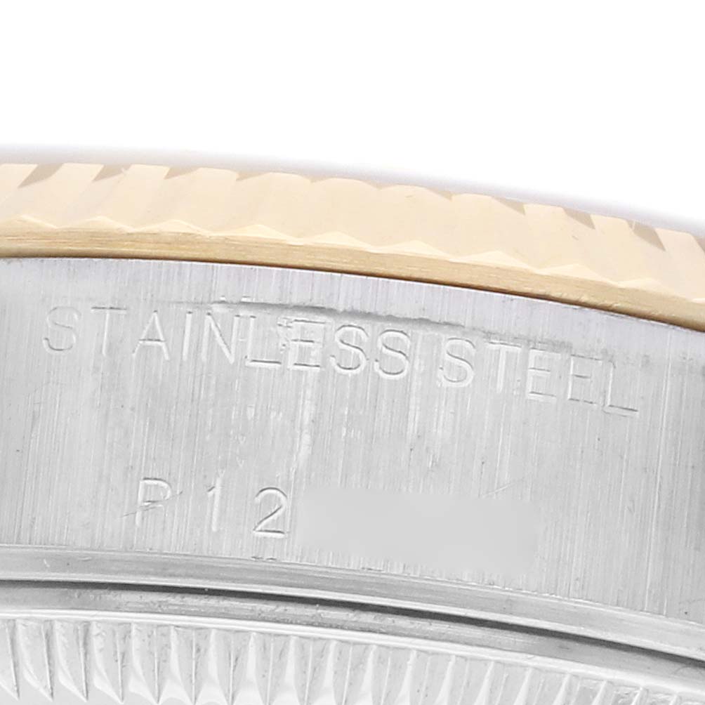 The image shows a close-up of the stainless steel case with "STAINLESS STEEL" engraved on a Rolex Datejust 79173 Women
s Steel and Gold (two tone) Mother of Pearl Dial.