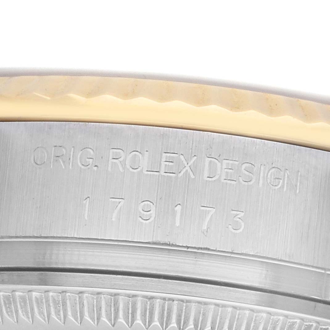 The image shows a close-up of the side of a Rolex Datejust 179173 Women
s Steel and Gold (two tone) Champagne Dial, focusing on the engraved watch case.