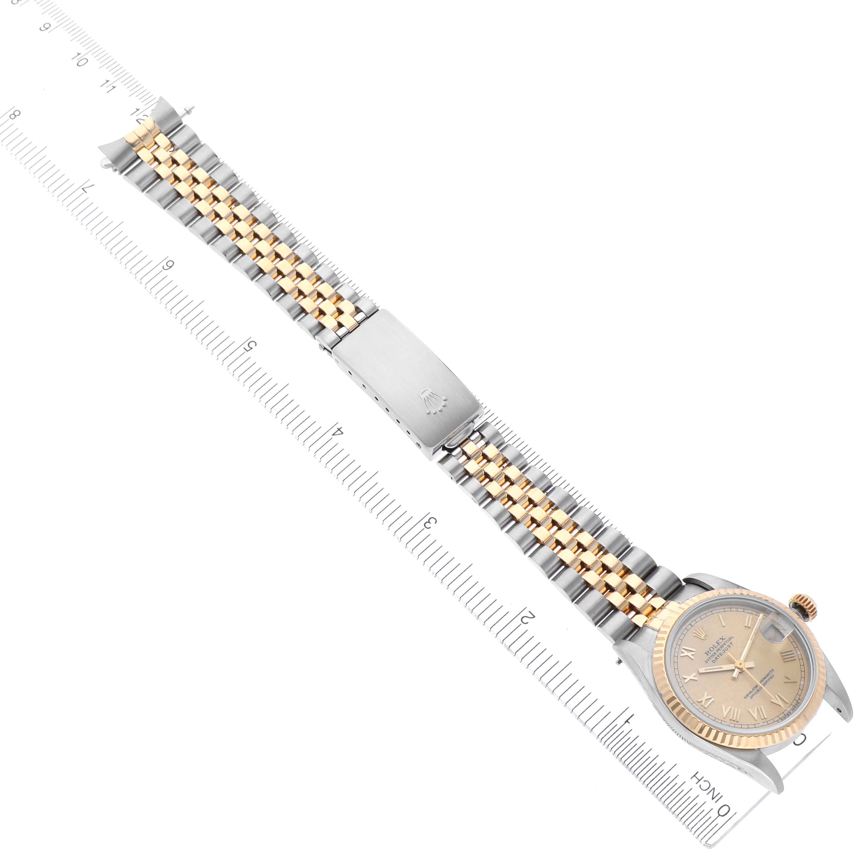 The image shows the Mid-Size Rolex watch flat with its full bracelet extended, positioned alongside a ruler for scale.