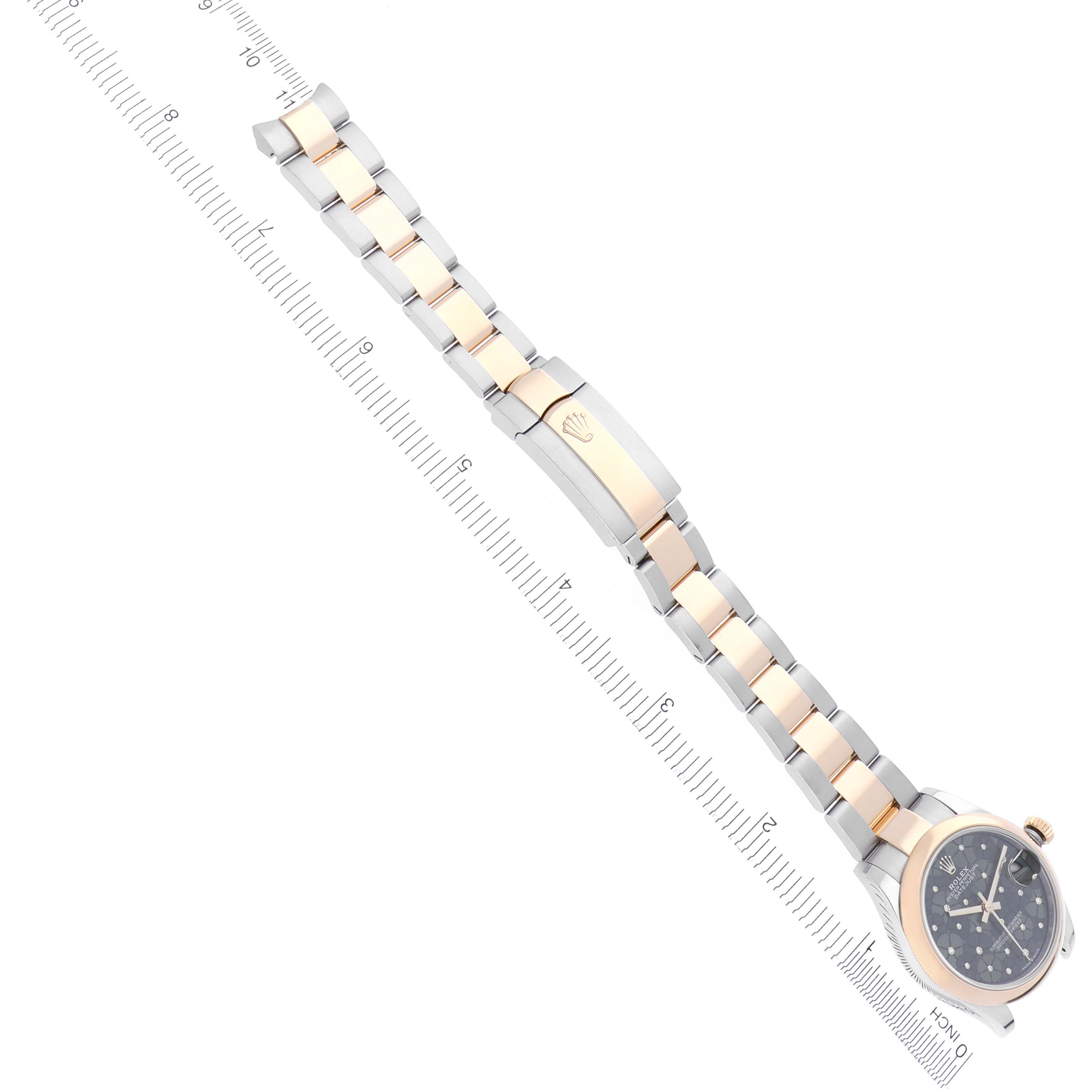 This image shows a top-down view of a Mid-Size Rolex watch with a bimetallic bracelet and clasp, accompanied by a ruler for scale.