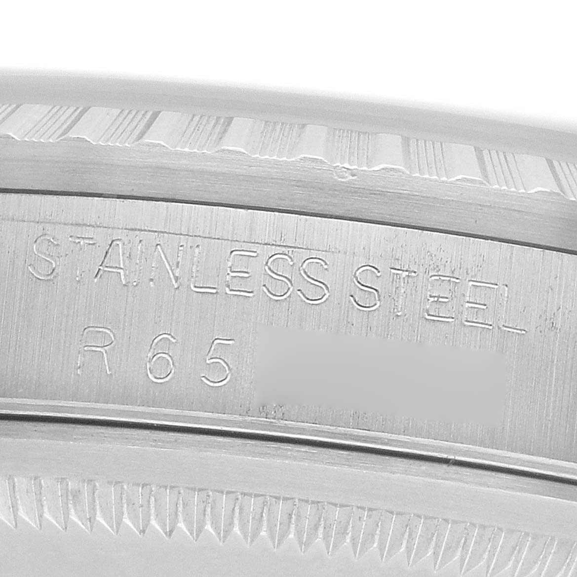 The image shows a close-up of the case edge of a Rolex Datejust 16220 Men
s Stainless Steel Silver Dial, highlighting the "STAINLESS STEEL" engraving.