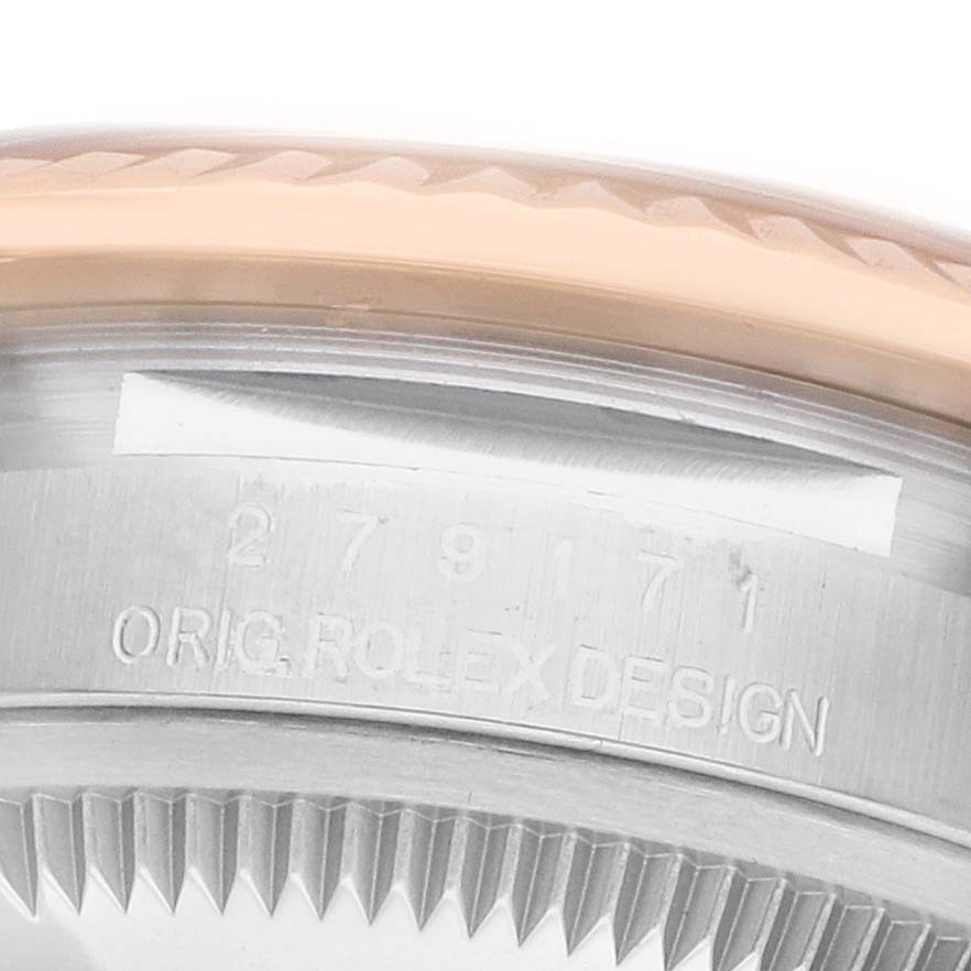 The image shows a close-up of the Rolex Datejust 279171 Women
s Steel and Gold (two tone) Silver Dial
s case side with engravings and the fluted bezel.