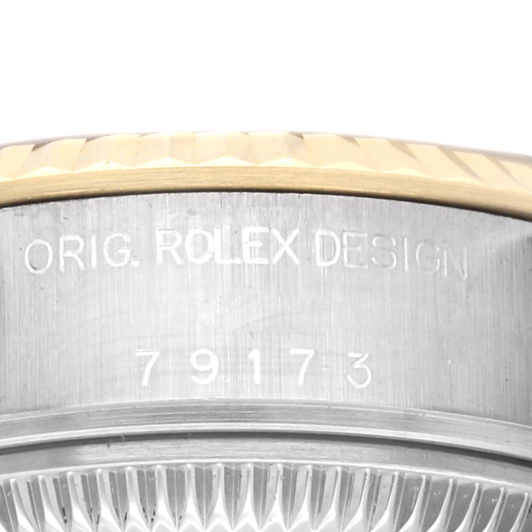 This close-up image shows the serial number and "ORIG. ROLEX DESIGN" engraving on the side of the bezel of a Rolex Datejust 79173 Women
s Steel and Gold (two tone) Champagne Dial 79173 Women
s Steel and Gold (two tone) Champagne Dial watch.