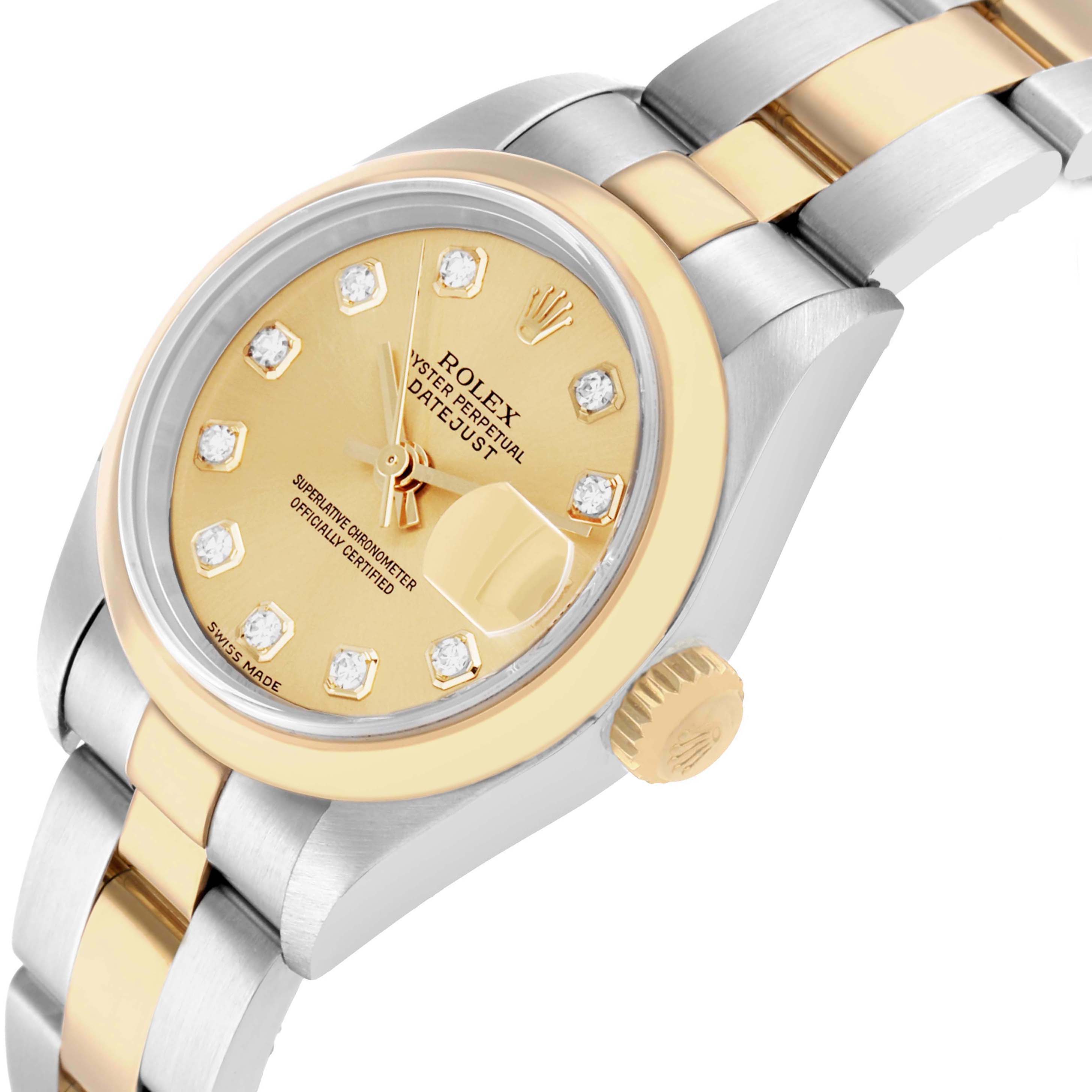 The image shows a Rolex Datejust 79163 Women
s Steel and Gold (two tone) Champagne Dial watch at a tilted angle, highlighting its gold dial, diamond hour markers, and two-tone bracelet.