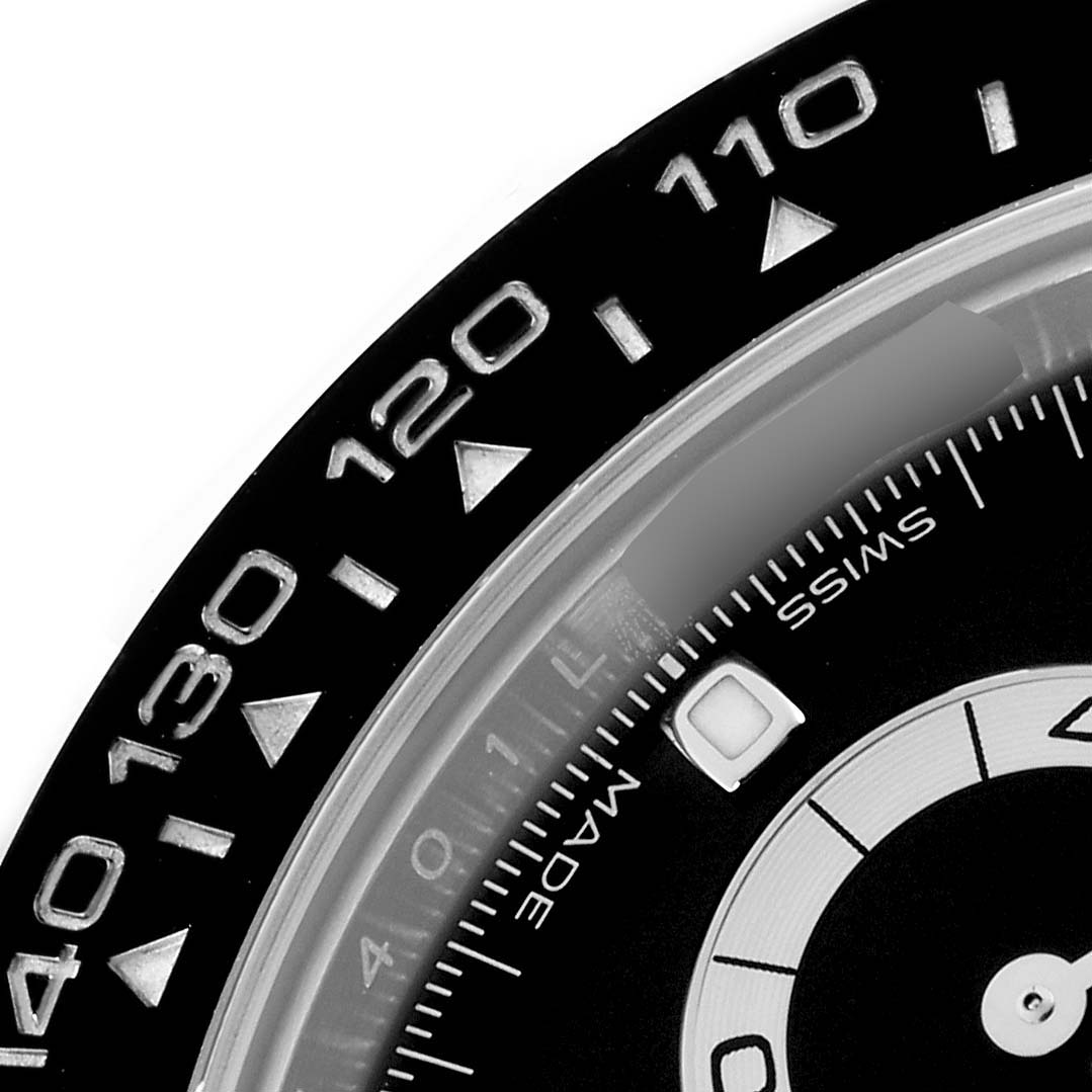 This image shows a close-up of the bezel and partial dial of a Rolex Daytona 116500 Men
s Stainless Steel Black Dial watch, highlighting the tachymetric scale and part of the subdial.