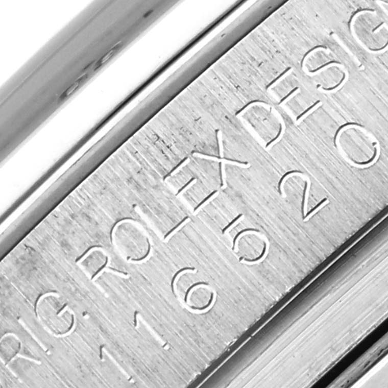 This close-up image features the engraved side of a Rolex Daytona 116520 Men's Stainless Steel Black Dial 116520 Men's Stainless Steel Black Dial watch, showing part of the serial or model number.