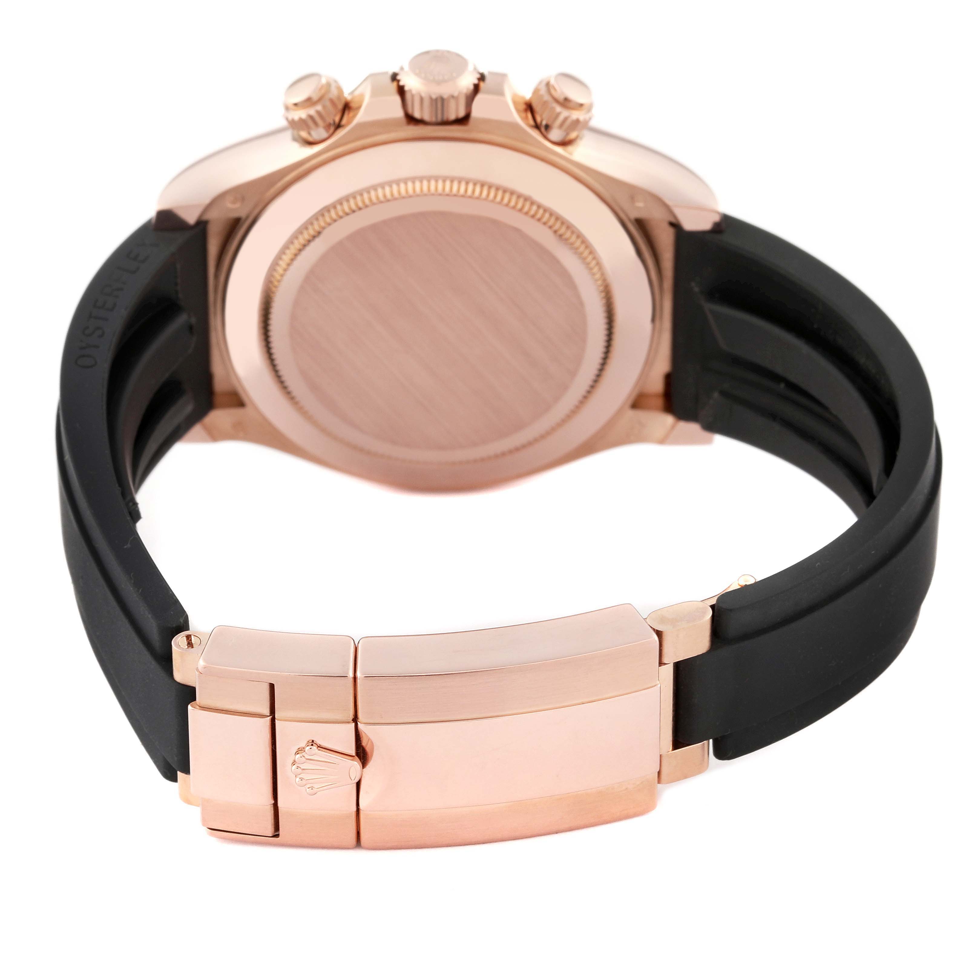 The image shows the back and clasp of a Rolex Daytona 116515 Men's Rose Gold Black Dial 116515 Men's Rose Gold Black Dial watch, featuring a rose gold case and black rubber strap.