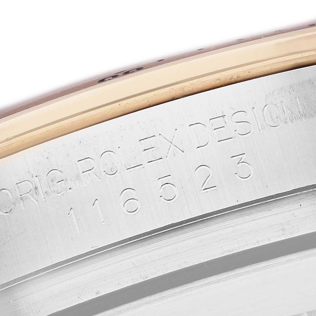 This image shows the engraved side of the bezel and case edge of a Rolex Daytona 116523 Men
s Steel and Gold (two tone) Mother of Pearl Dial watch.