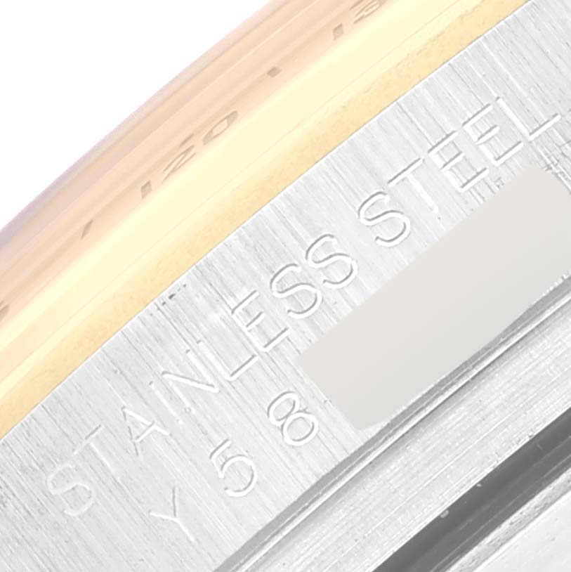 This close-up image shows the engraved text and metal details on the side of a Rolex Daytona 116523 Men's Steel and Gold (two tone) Silver Dial 116523 Men's Steel and Gold (two tone) Silver Dial watch case.