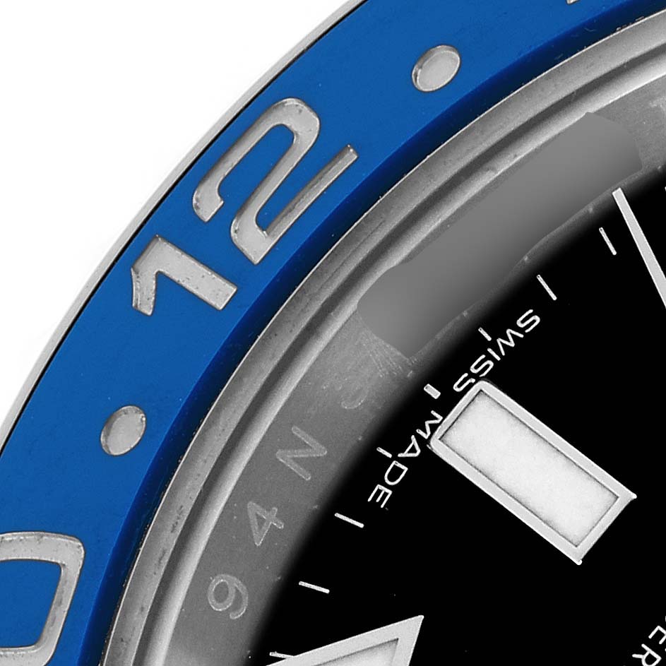 The image shows a close-up of the bezel and part of the dial of a Rolex GMT-Master 116710 Men
s Stainless Steel Black Dial watch, featuring blue and silver elements.