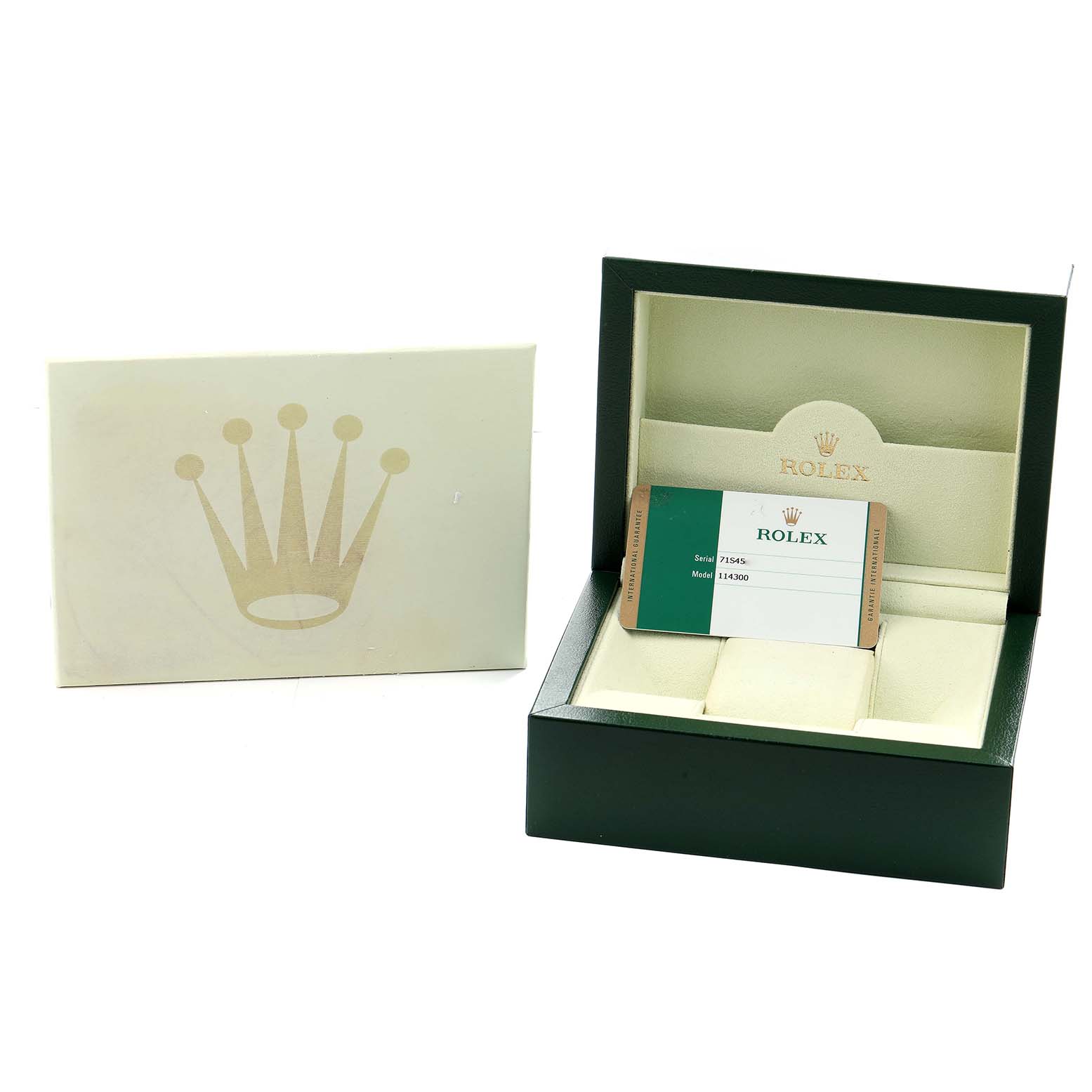 The image shows the packaging and warranty card for a Rolex Oyster Perpetual 114300 Men
s Stainless Steel Blue Dial watch.