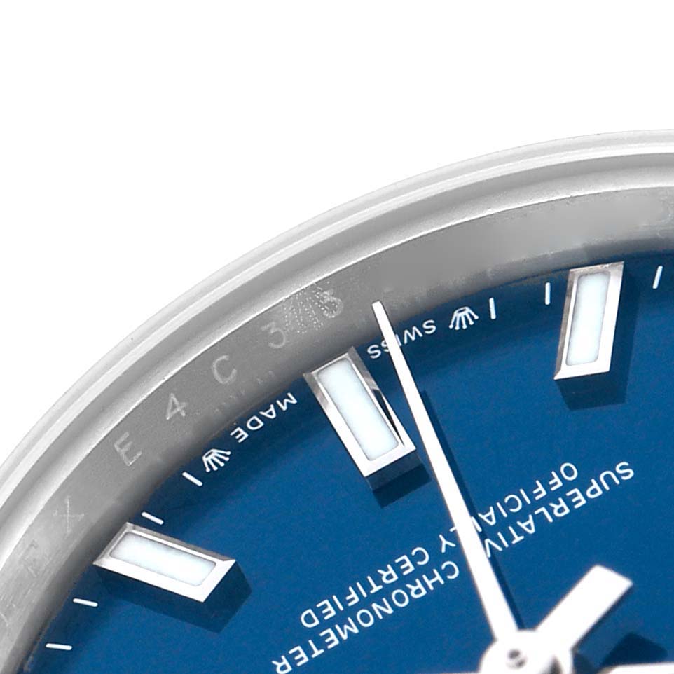The image shows a close-up of the Rolex Oyster Perpetual 276200 Women
s Stainless Steel Blue Dial watch
s blue dial, markers, and part of the bezel at an angled view.