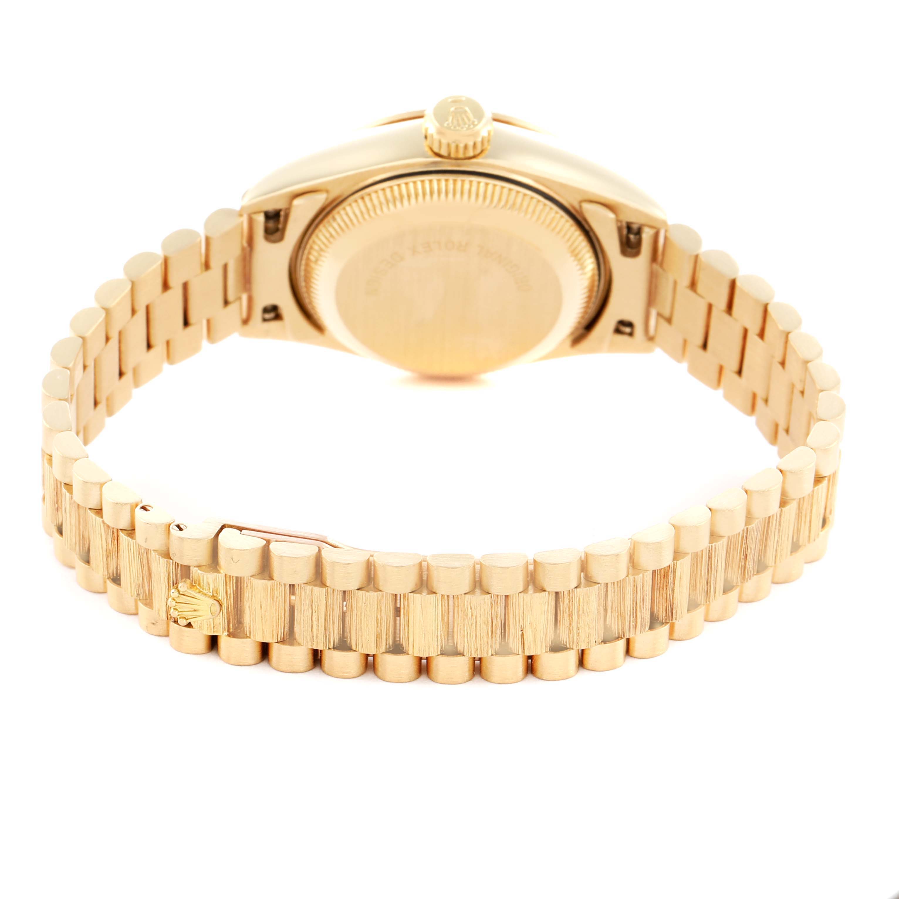 The image shows the back and bracelet of a Rolex President 69278 Women
s Yellow Gold Champagne Dial model, highlighting the clasp and the case
s crown.