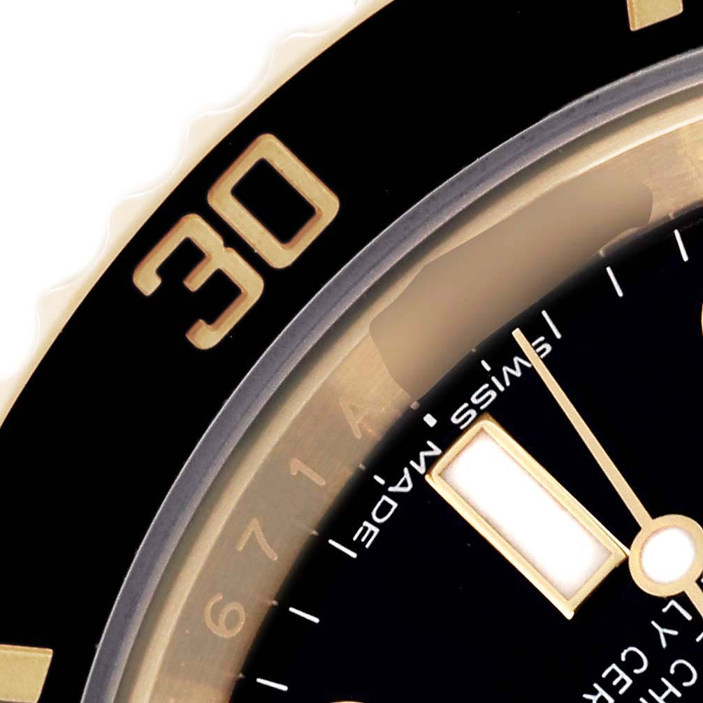 The image shows a close-up of the bezel and watch face of the Rolex Submariner 116618 Men
s Yellow Gold Black Dial 116618 Men
s Yellow Gold Black Dial, emphasizing the 30-minute marker and part of the dial.