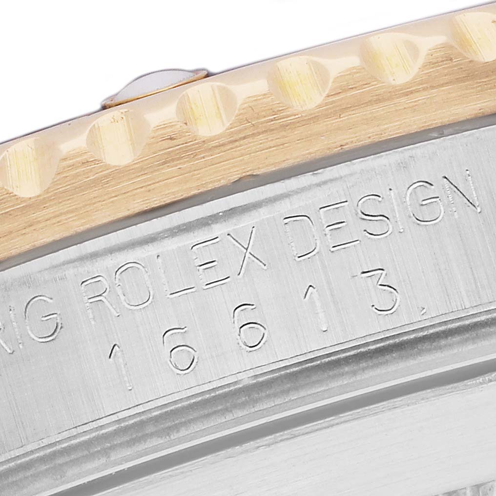 The image shows a close-up of the bezel and case side of a Rolex Submariner 16613 Men
s Steel and Gold (two tone) Blue Dial, including the model number engraving.