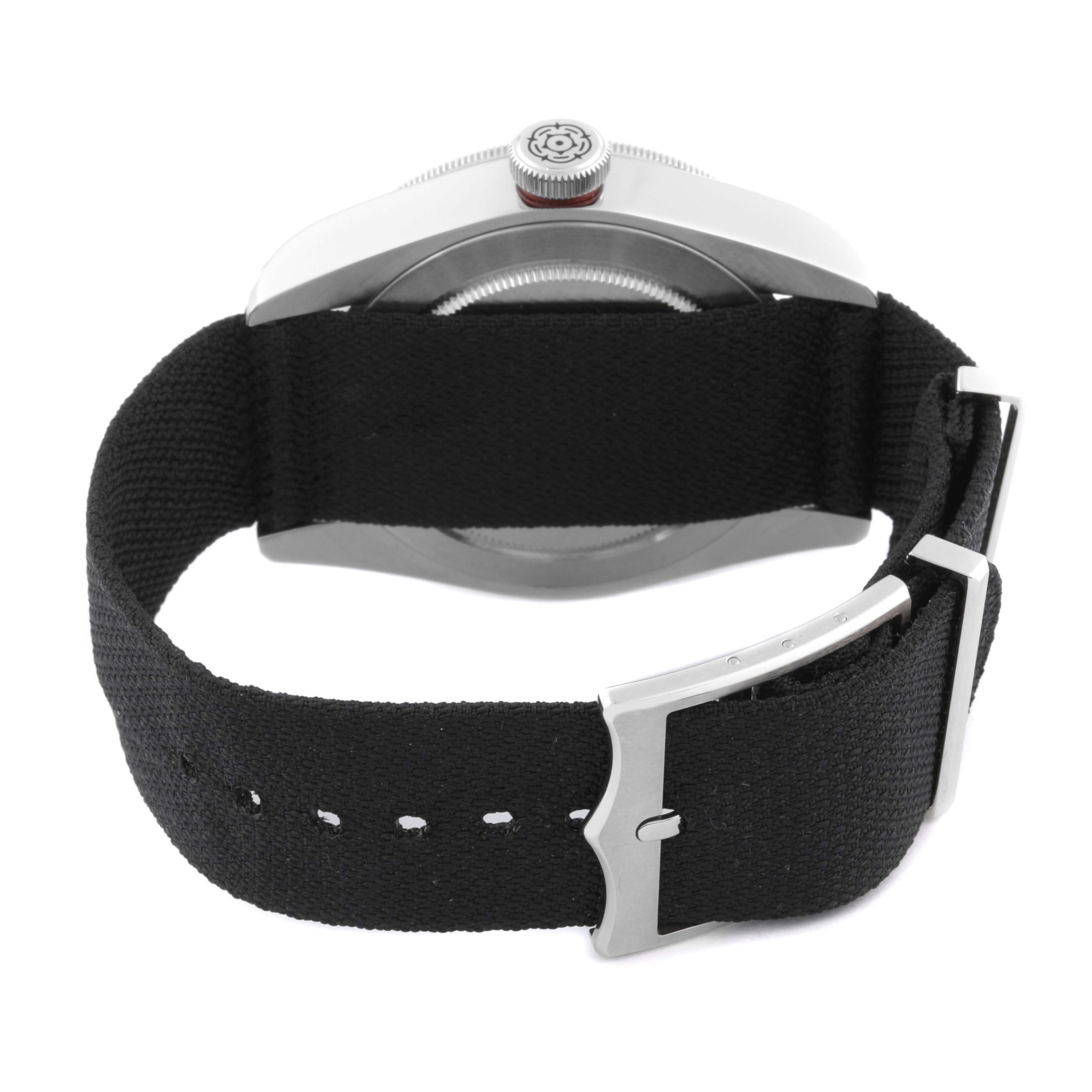 The image shows the back view of a Tudor Heritage Black Bay 79220R Men's Stainless Steel Black Dial 79220R Men's Stainless Steel Black Dial watch with a black fabric strap and buckle.