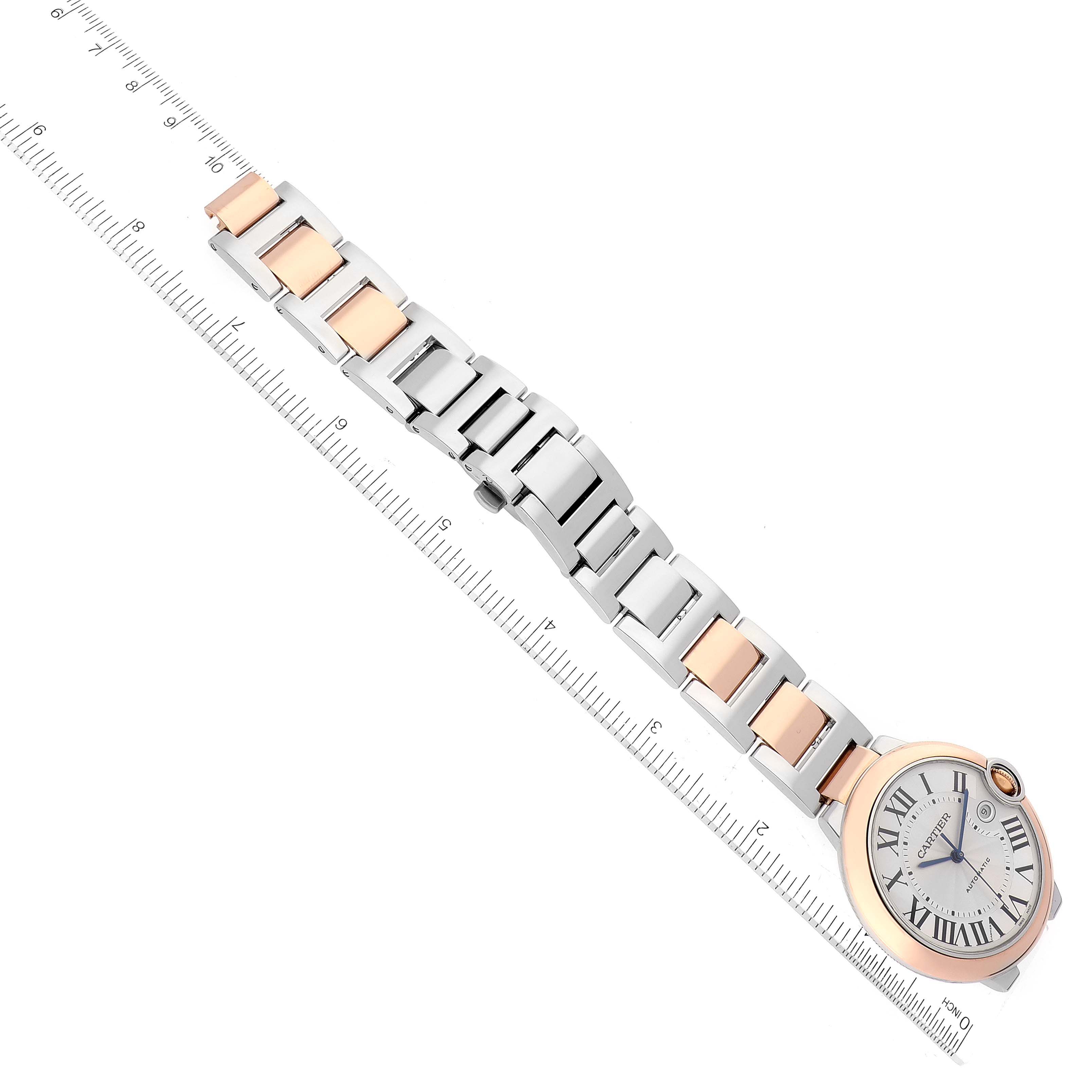 This image shows the Cartier Ballon Bleu W2BB0004 Men's Steel and Gold (two tone) Silver Dial W2BB0004 Men's Steel and Gold (two tone) Silver Dial watch from an overhead angle, highlighting its face, bezel, and the metal bracelet with a ruler for scale.