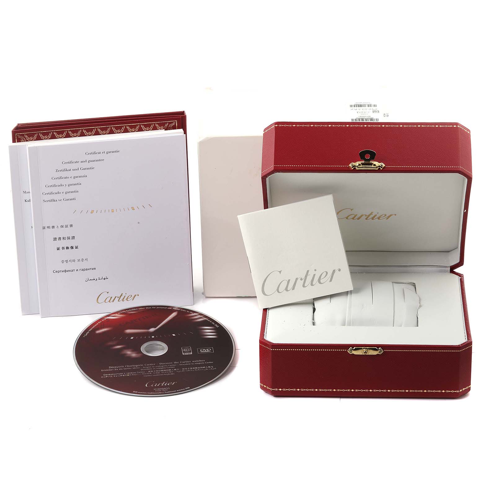 The image shows the accessories of a Calibre de Cartier watch by Cartier, including the watch box, manuals, and a CD, displayed from a top angle.