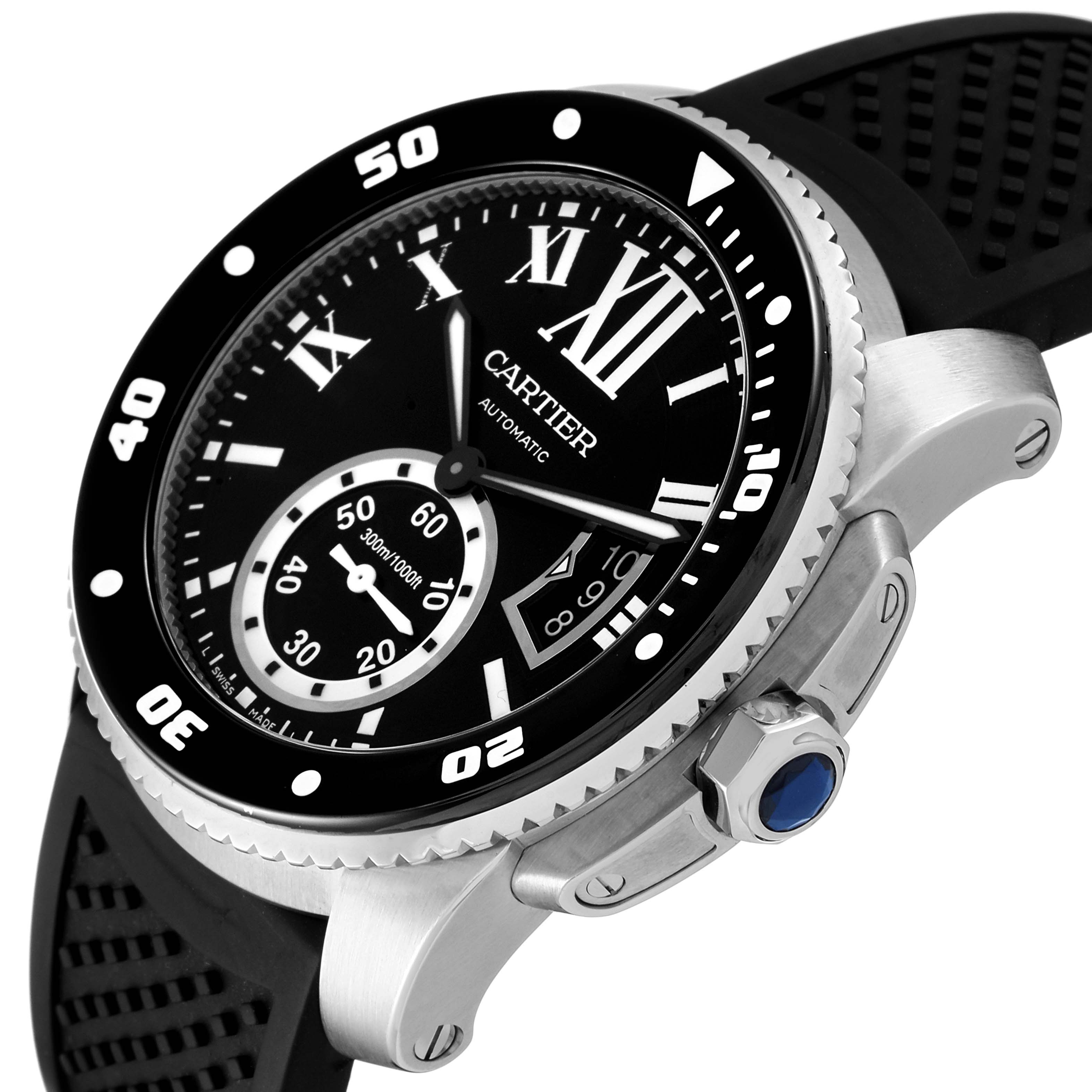 This image shows the dial, bezel, crown with blue cabochon, and part of the strap of the Calibre de Cartier model by Cartier from an angled perspective.