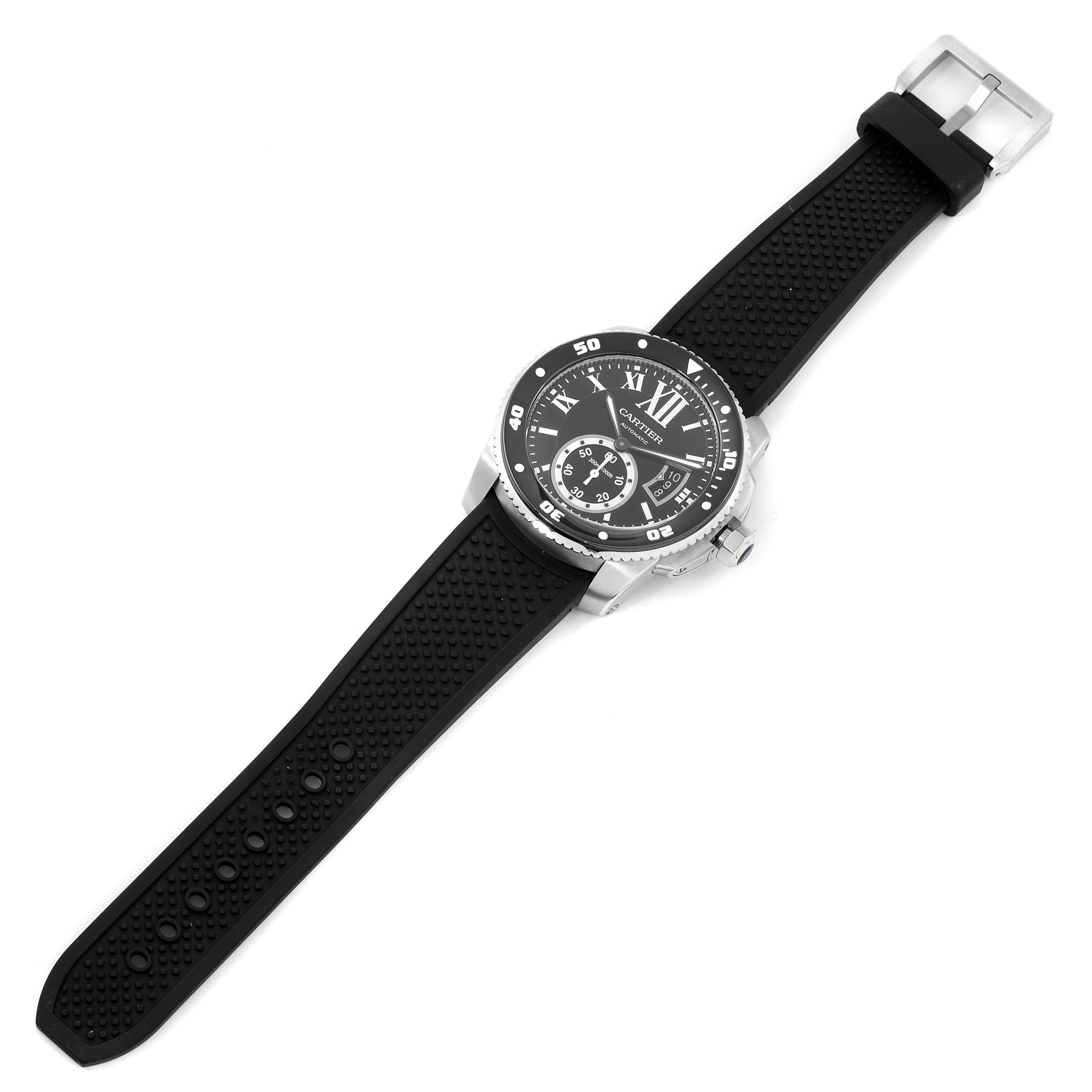 The image shows a top-down view of the Calibre de Cartier model by Cartier, revealing the watch face, bezel, strap, and buckle.