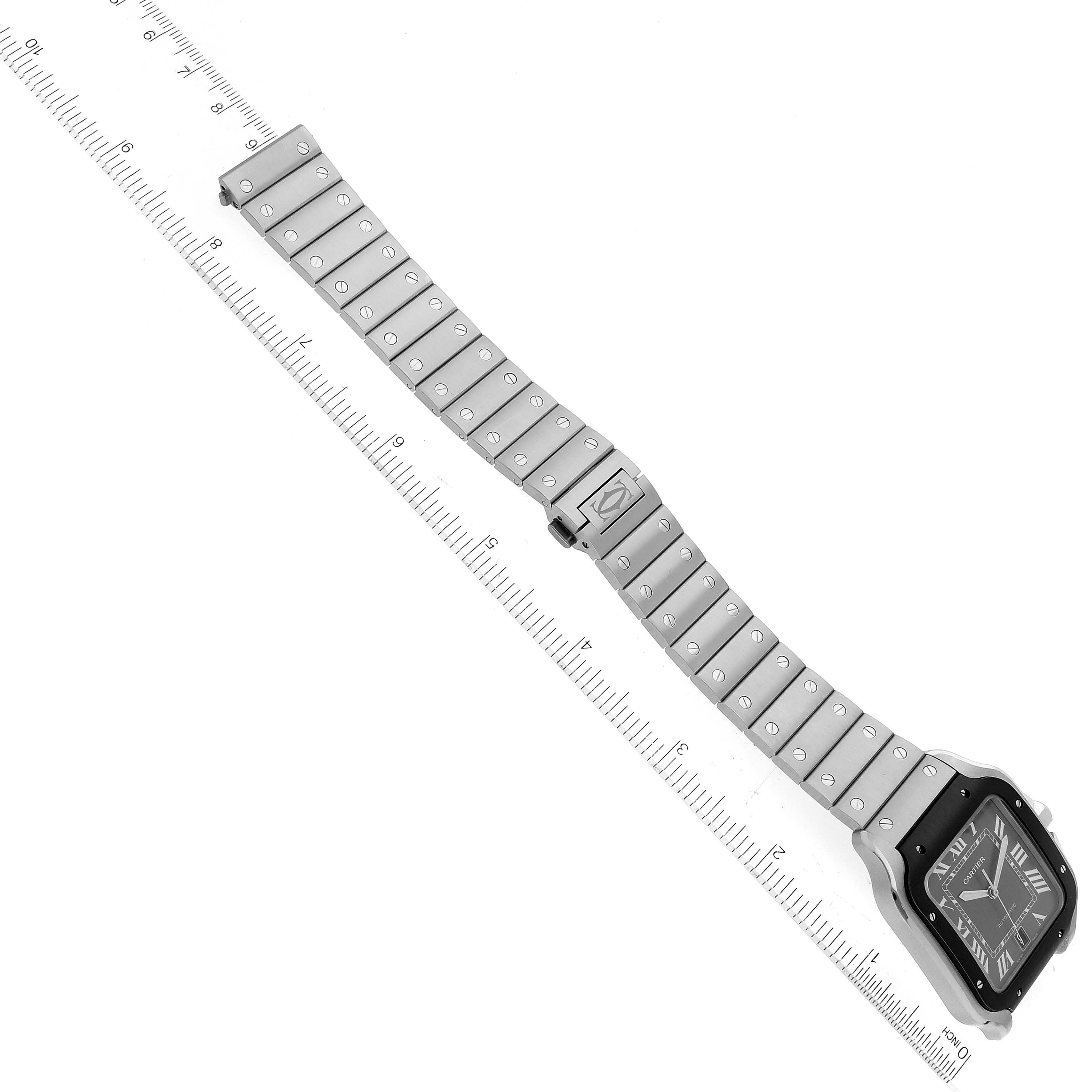 The image shows a Cartier Santos WSSA0037 Men's Stainless Steel Grey Dial WSSA0037 Men's Stainless Steel Grey Dial watch laid flat with its band extended alongside a ruler, displaying the watch face and the full band length.