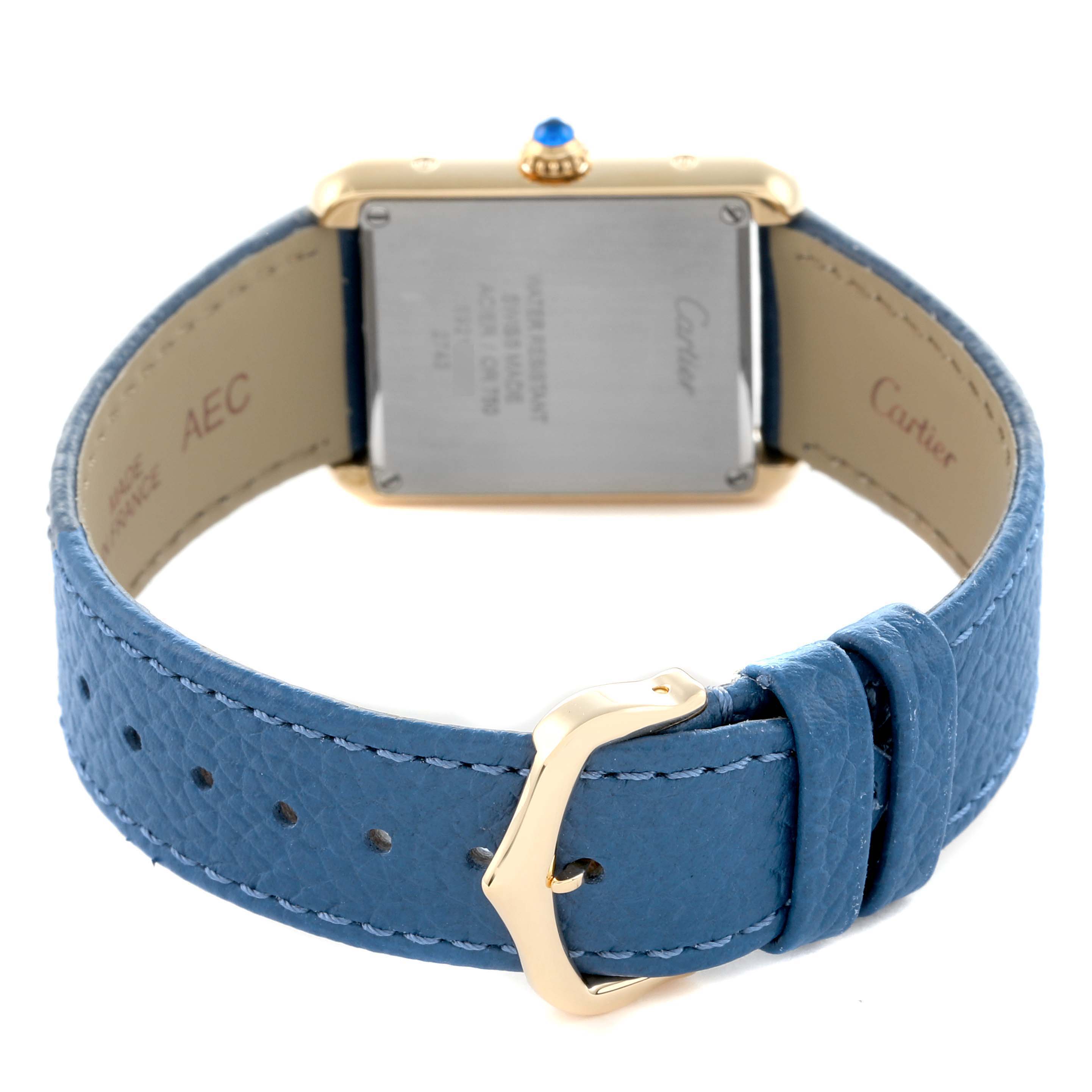 The Cartier Tank Solo W1018755 Women
s Yellow Gold Silver Dial watch is shown from the back, highlighting the case back, crown, and blue leather strap with a buckle.