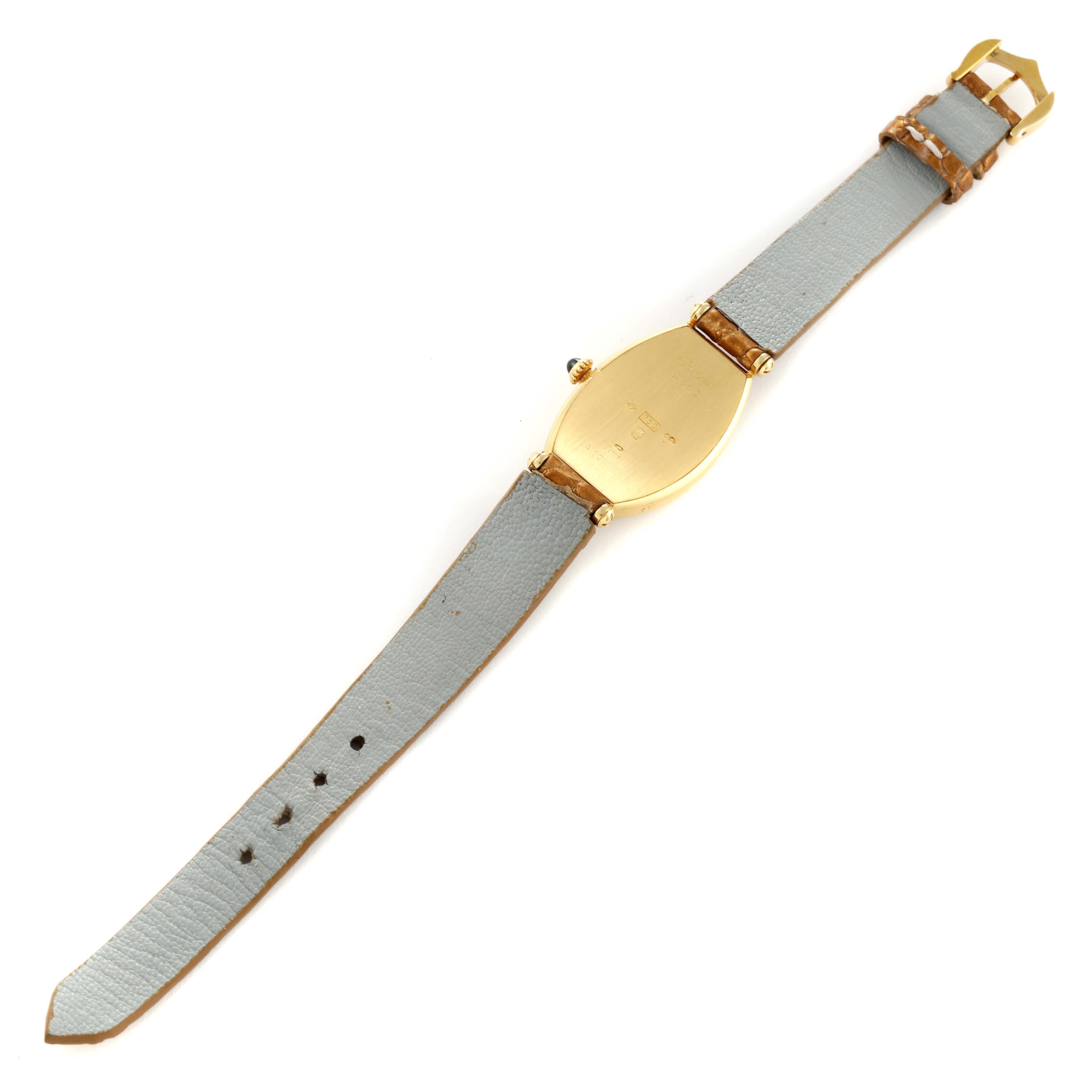 This image shows the back view of a Cartier Tonneau Women
s Yellow Gold Silver Dial Women
s Yellow Gold Silver Dial watch, highlighting the gold case and gray leather strap.