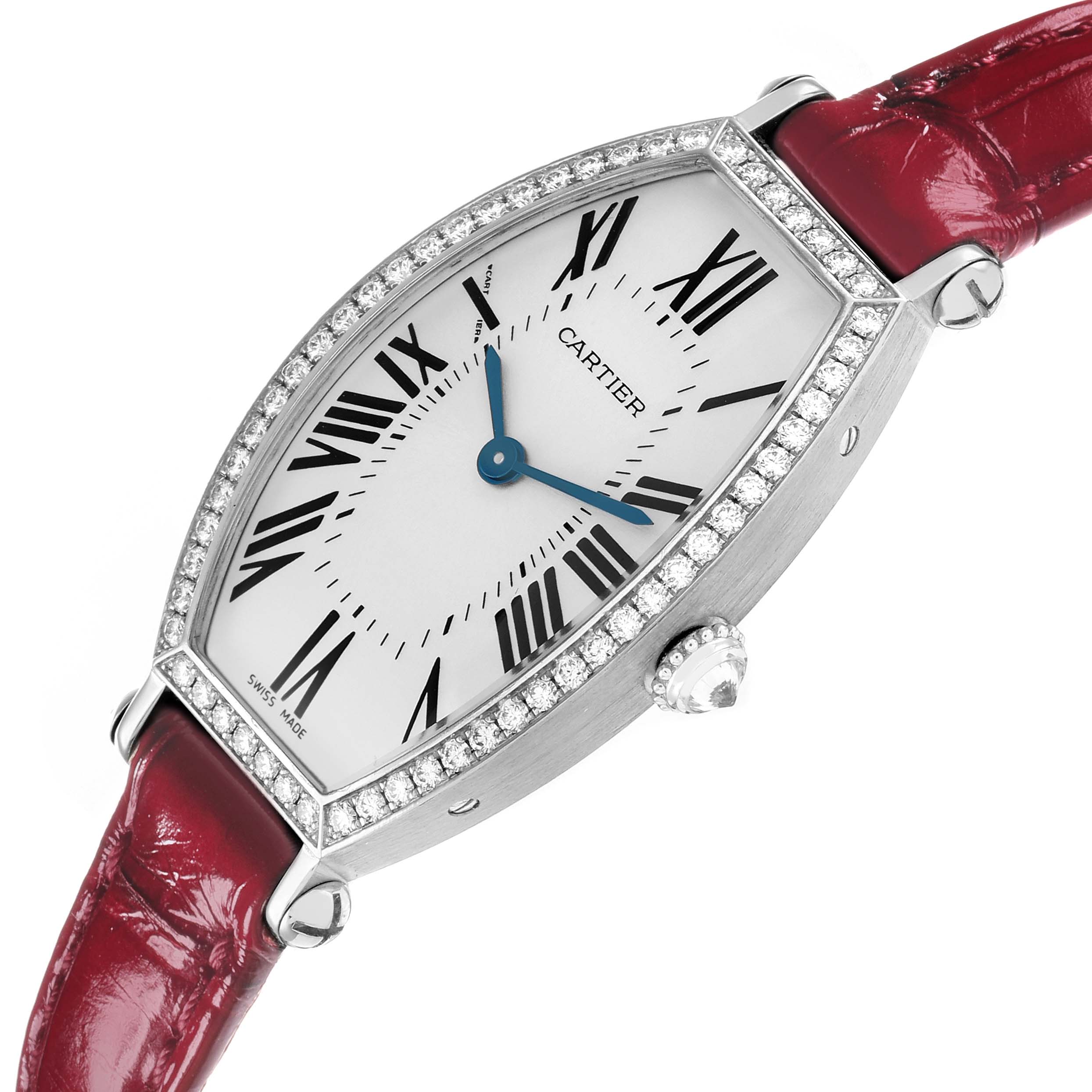 The Cartier Tonneau WE400131 Women
s White Gold Silver Dial watch is shown at an angled view, highlighting its case, Roman numeral dial, crown, and red strap.