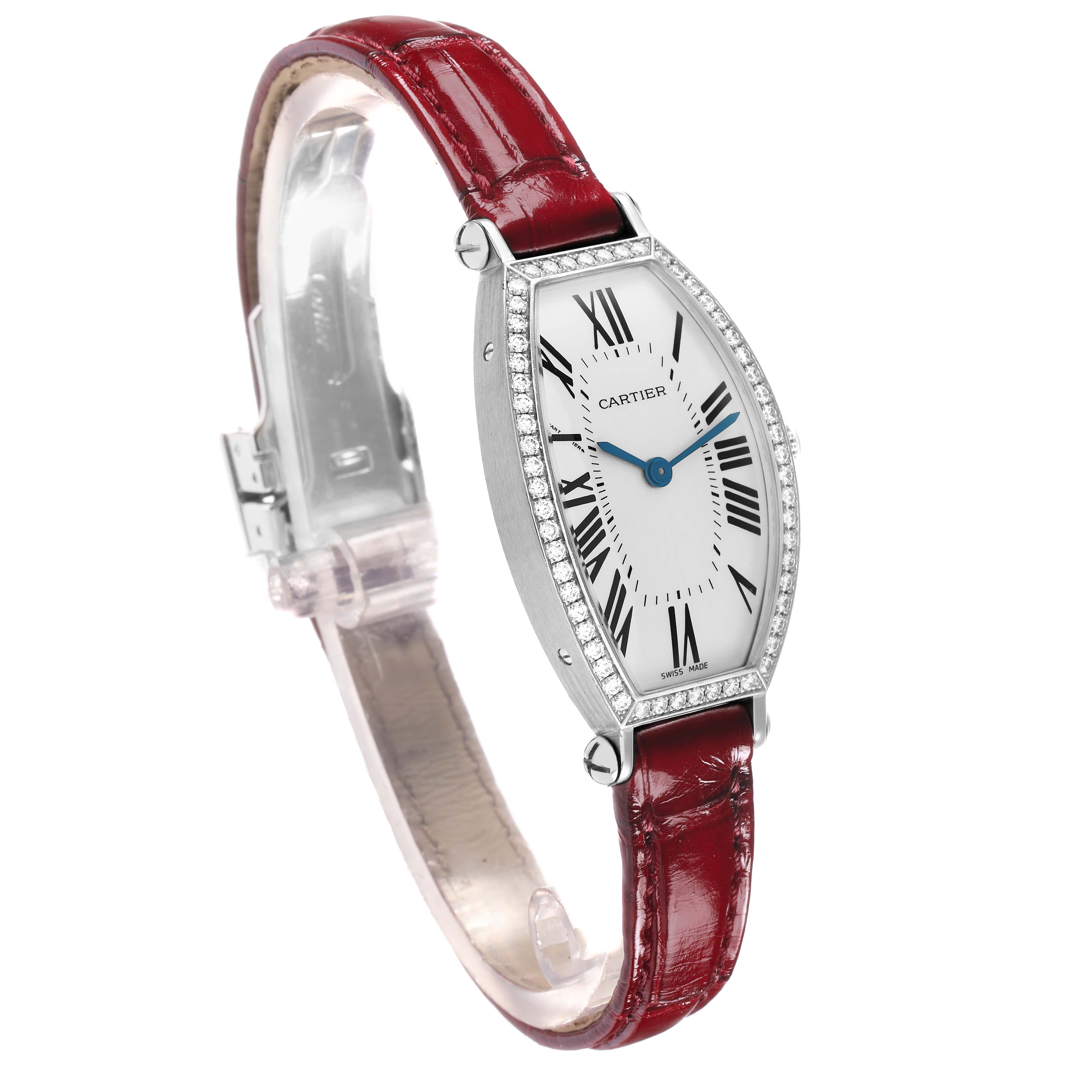 The Cartier Tonneau WE400131 Women
s White Gold Silver Dial watch is shown at a slight angle, highlighting the red leather strap, diamond bezel, and dial with Roman numerals.