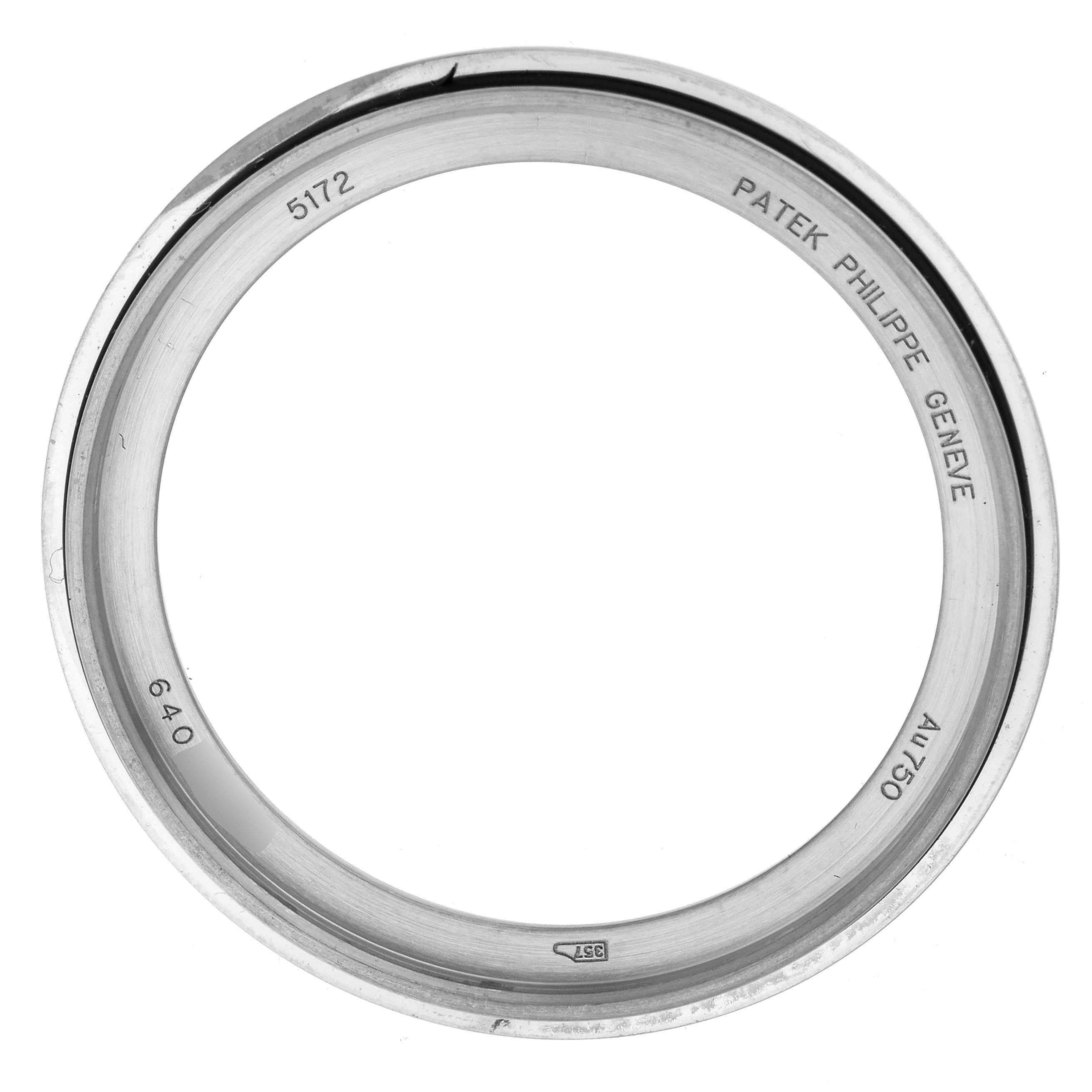 The image shows the bezel of a Patek Philippe Complications 5172G Men
s White Gold Black Dial watch, displaying engravings and a polished finish.